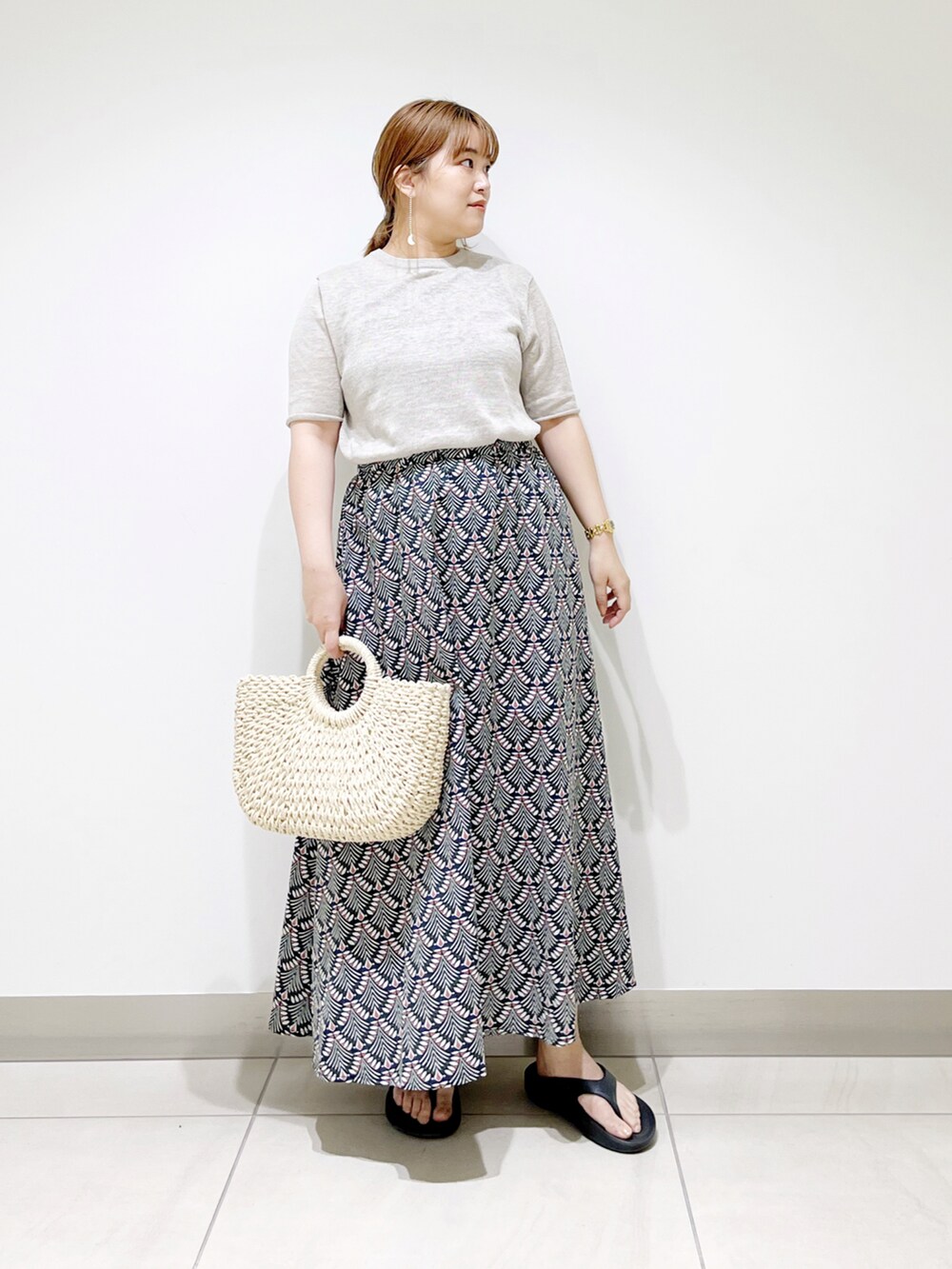 グリーン系のスカート、ベージュ系のTシャツ/カットソー、ホワイト系のハンドバッグを着用したレディースの春コーディネートの5枚目の写真