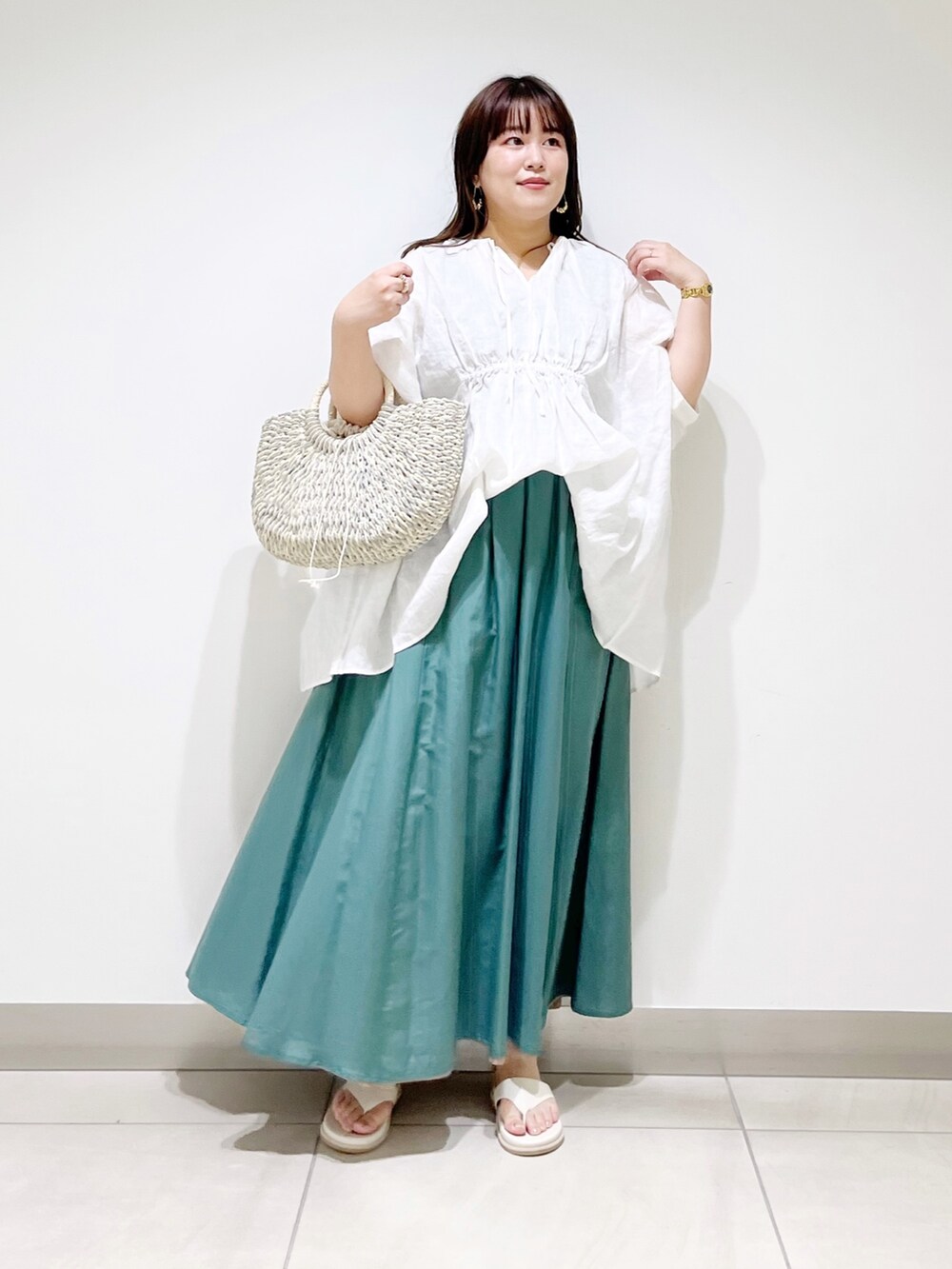ホワイト系のシャツ/ブラウス、グリーン系のスカート、グレー系のかごバッグを着用したレディースの夏コーディネートの2枚目の写真