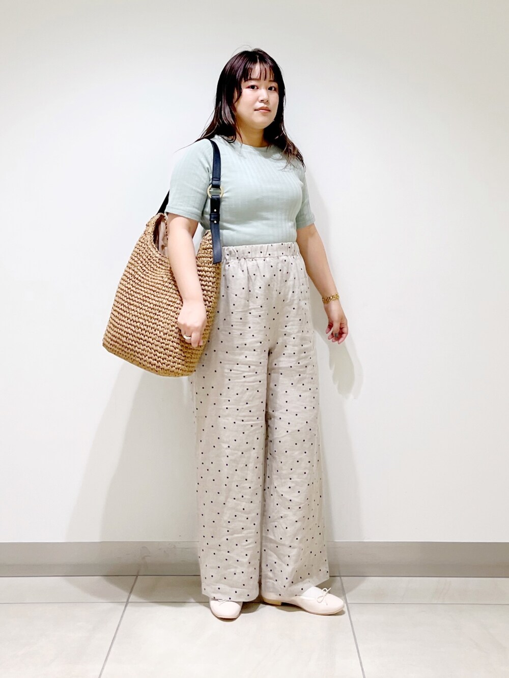 グリーン系のTシャツ/カットソー、ベージュ系のその他パンツ、ブラウン系のバッグを着用したレディースの春コーディネートの6枚目の写真