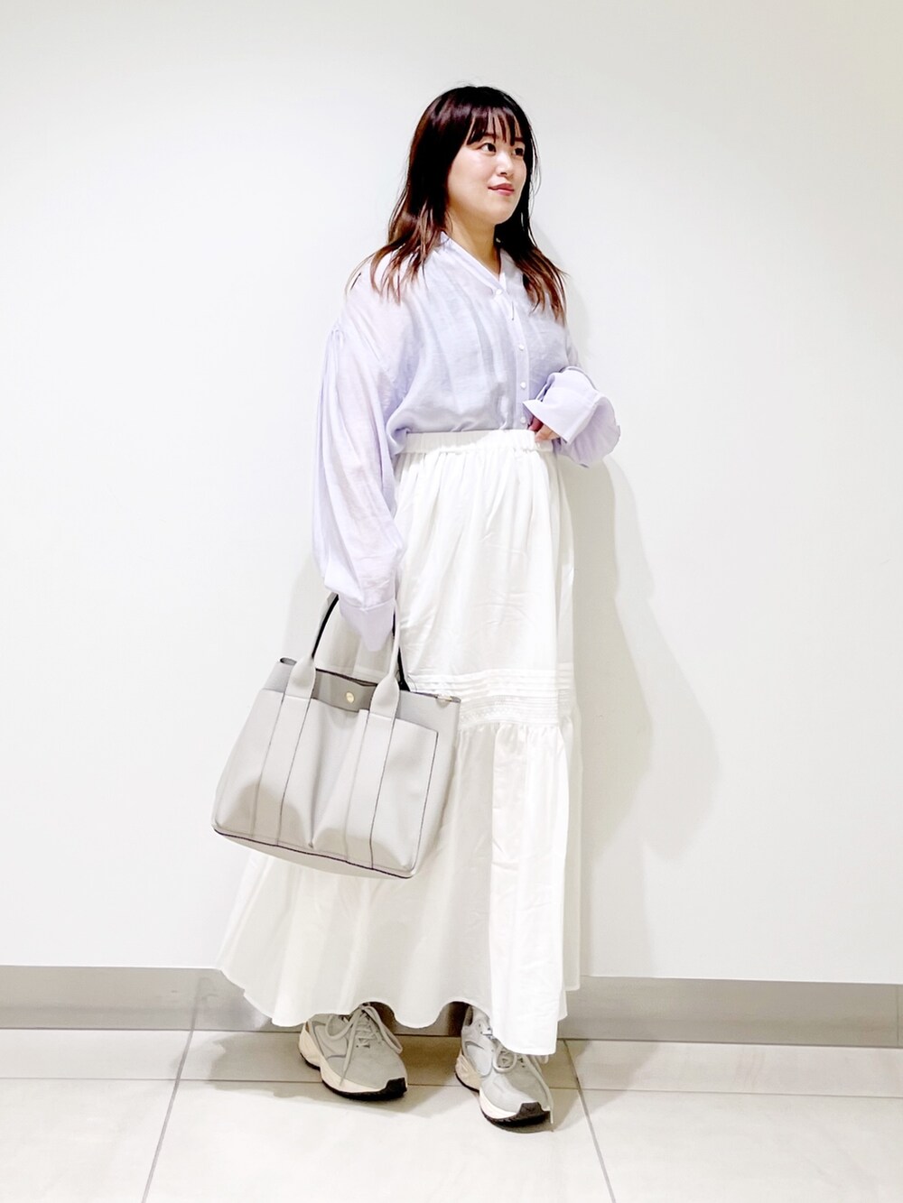 パープル系のシャツ/ブラウス、ホワイト系のスカート、グレー系のトートバッグを着用したレディースの夏コーディネートの2枚目の写真