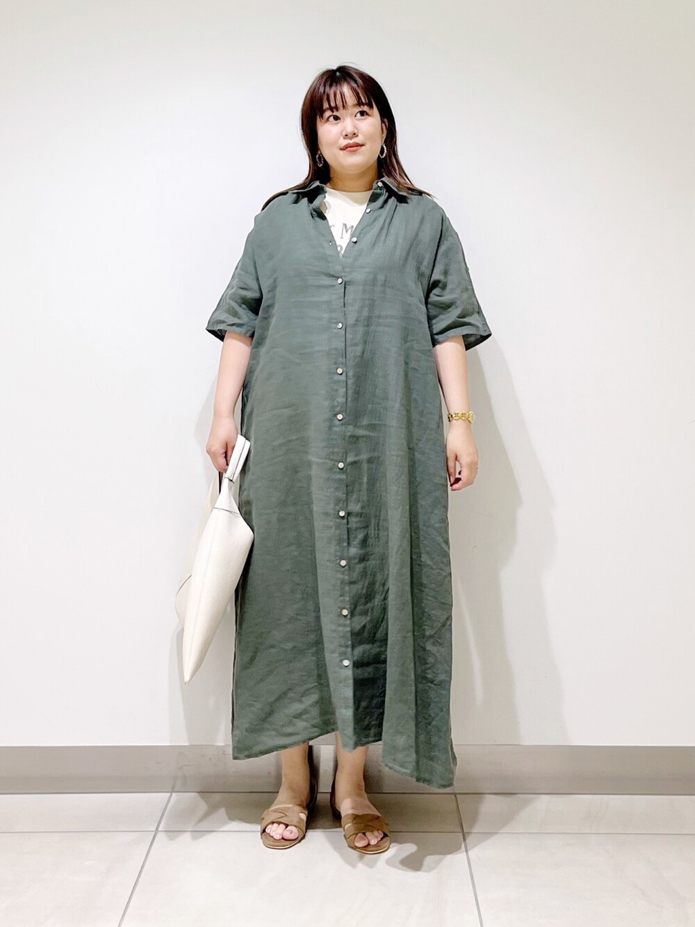 グリーン系のワンピース、ホワイト系のトートバッグ、ベージュ系のサンダルを着用したレディースの春コーディネートの9枚目の写真