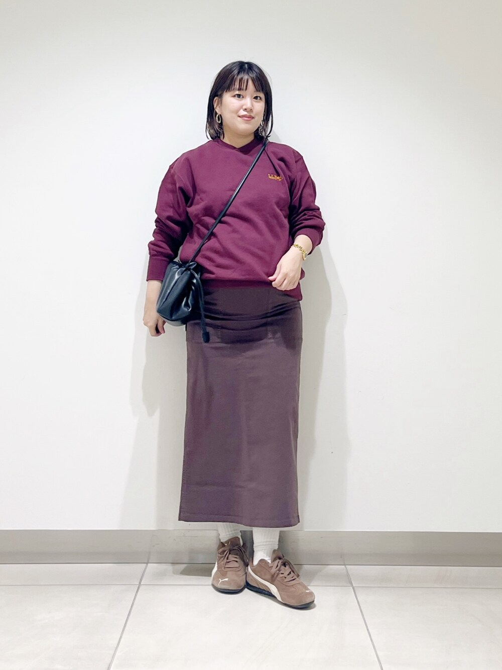 ブラウン系のスウェット、ブラウン系のスカート、ブラック系のスニーカーを着用したレディースの秋コーディネートの7枚目の写真