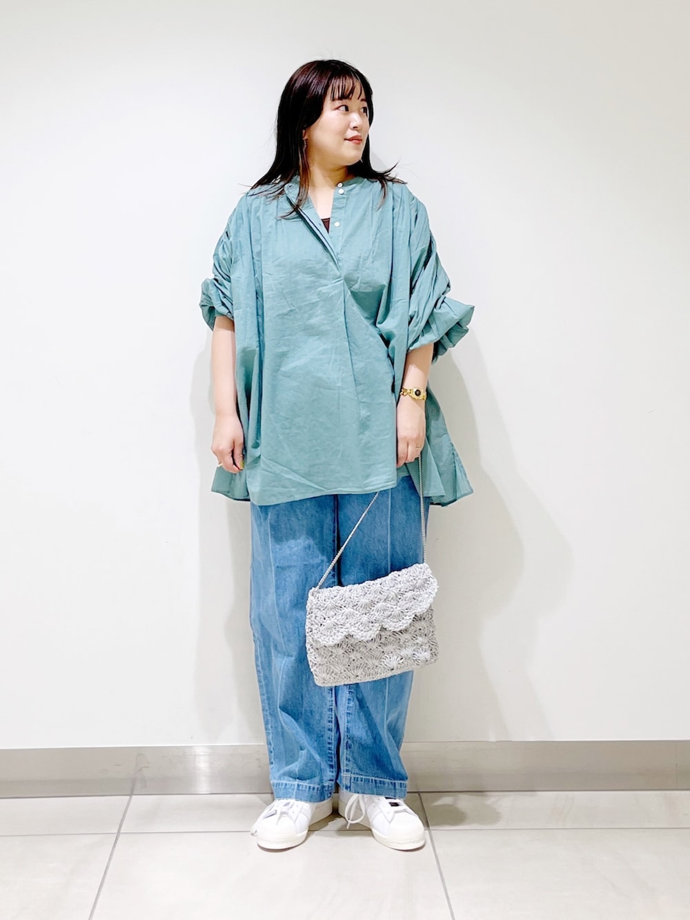 グリーン系のシャツ/ブラウス、ブルー系のデニムパンツ、シルバー系のバッグを着用したレディースの春コーディネートの4枚目の写真