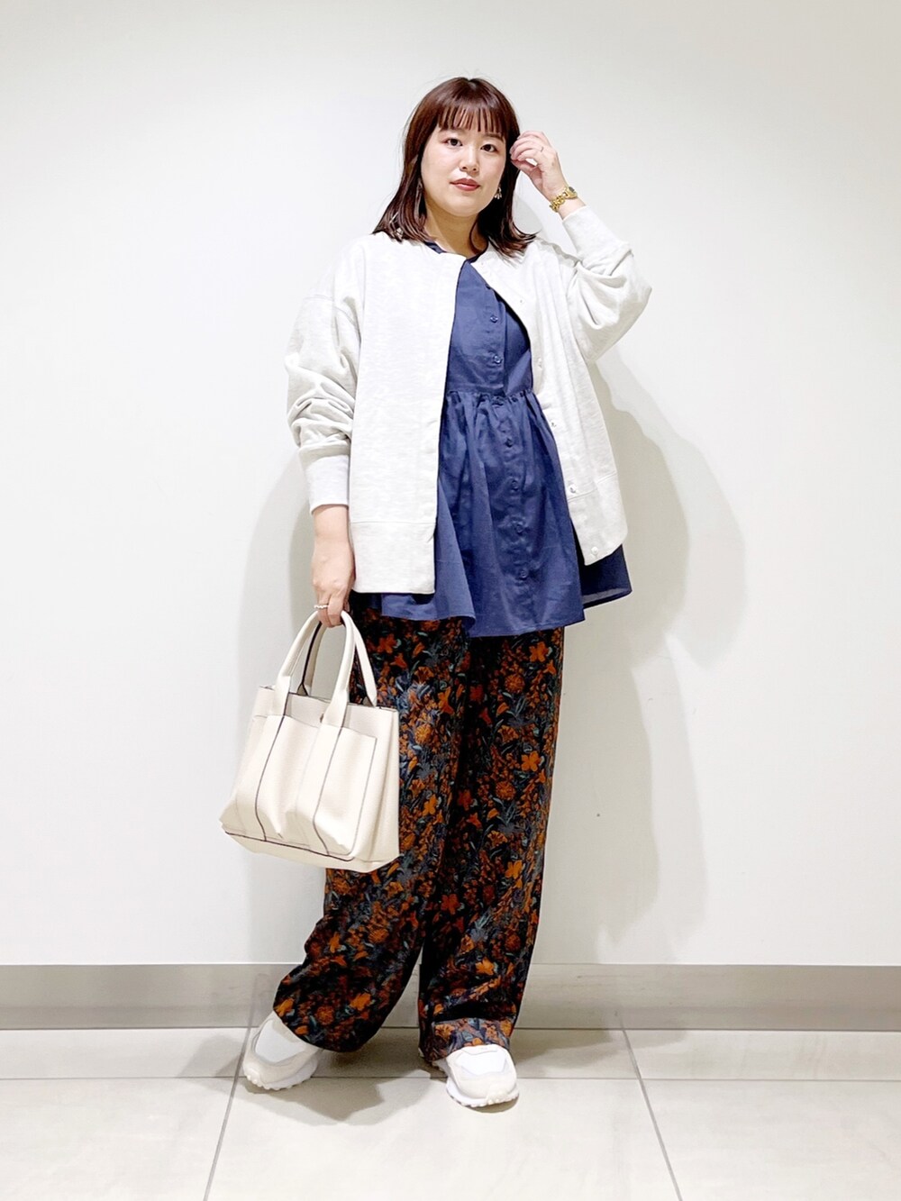 グレー系のカーディガン/ボレロ、ブルー系のシャツ/ブラウス、グレー系のトートバッグを着用したレディースの秋コーディネートの9枚目の写真