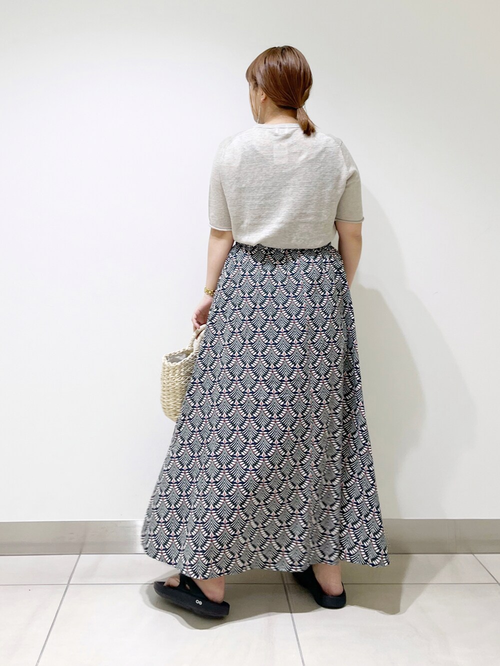 グリーン系のスカート、ベージュ系のTシャツ/カットソー、ホワイト系のハンドバッグを着用したレディースの春コーディネートの4枚目の写真