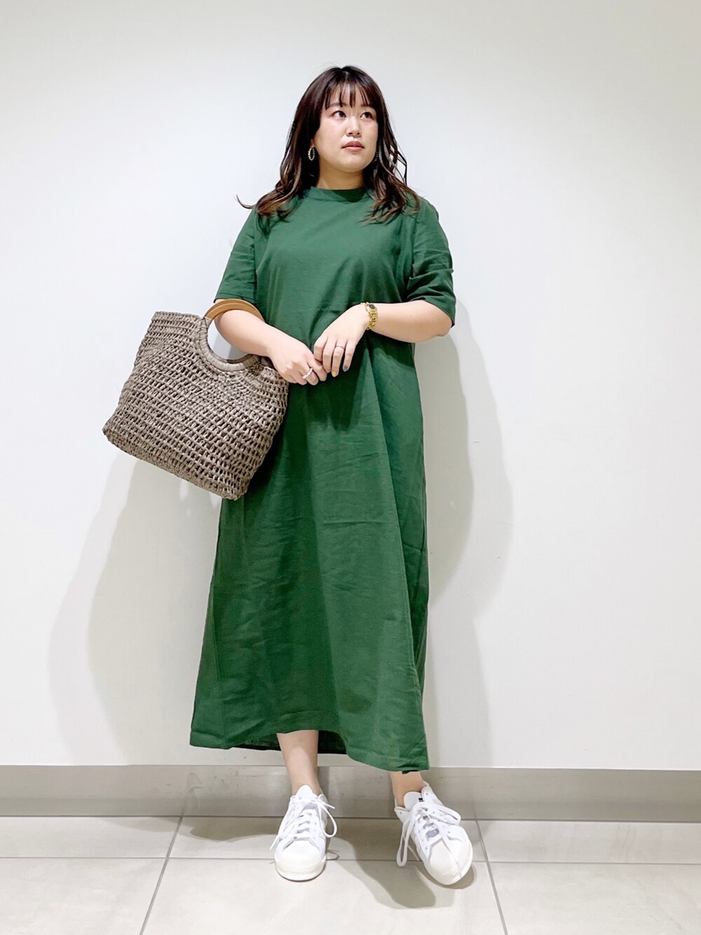 グリーン系のワンピース、グレー系のかごバッグ、ホワイト系のスニーカーを着用したレディースの夏コーディネートの4枚目の写真