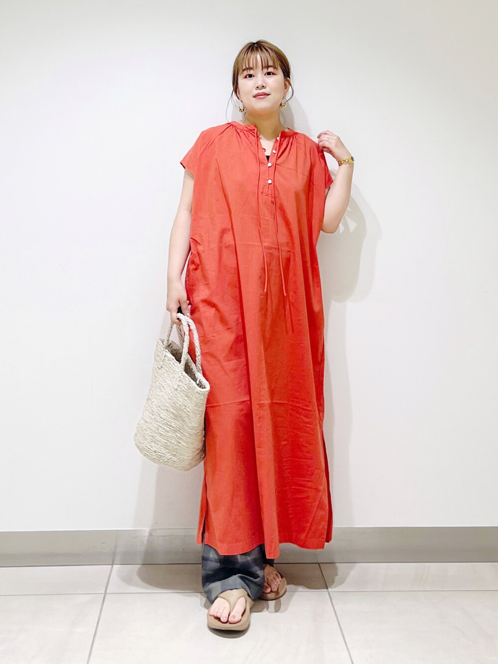 オレンジ系のワンピース、グレー系のトートバッグ、ベージュ系のサンダルを着用したレディースの春コーディネートの4枚目の写真