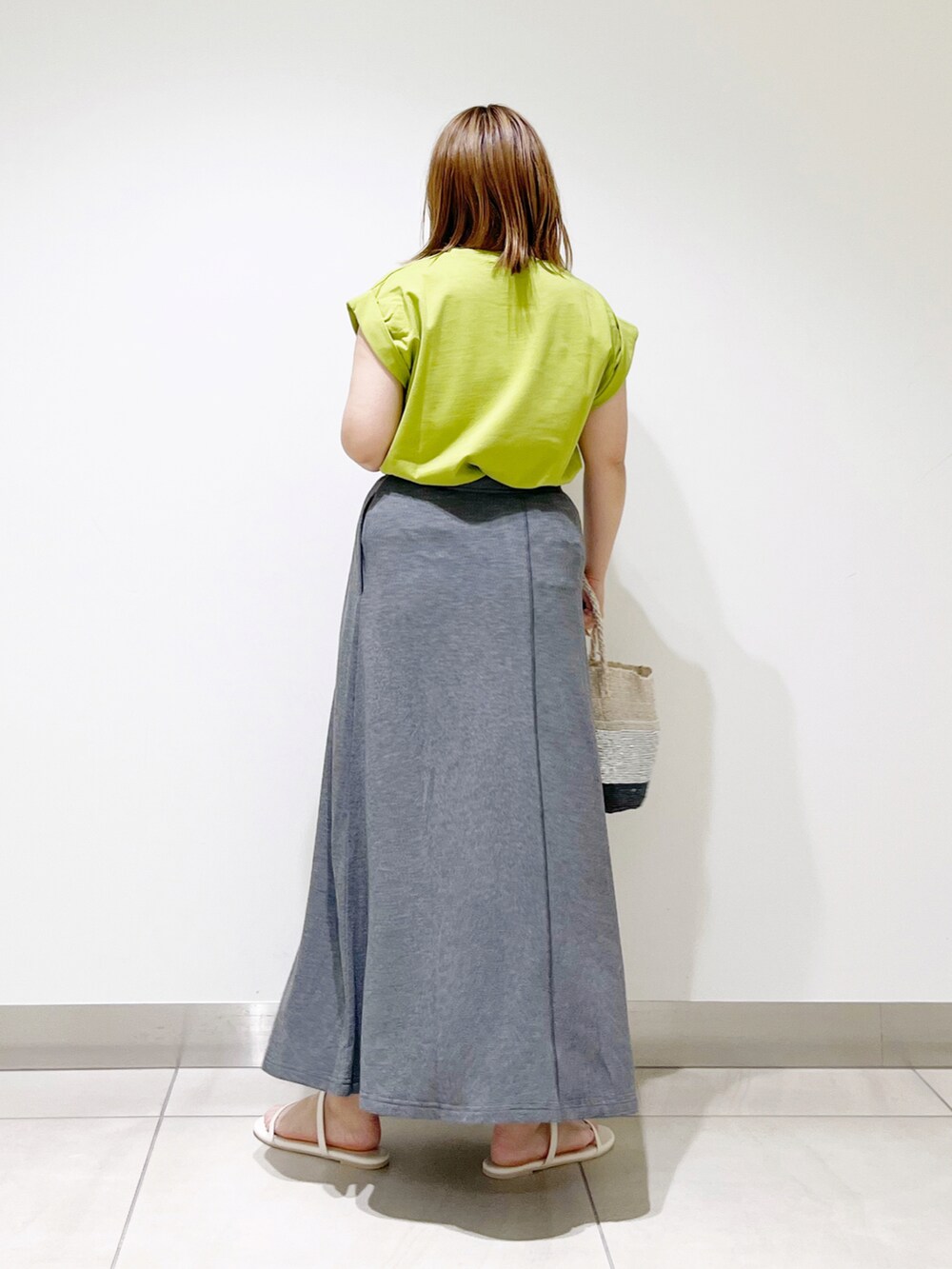 グリーン系のTシャツ/カットソー、グレー系のスカート、その他のハンドバッグを着用したレディースの夏コーディネートの4枚目の写真