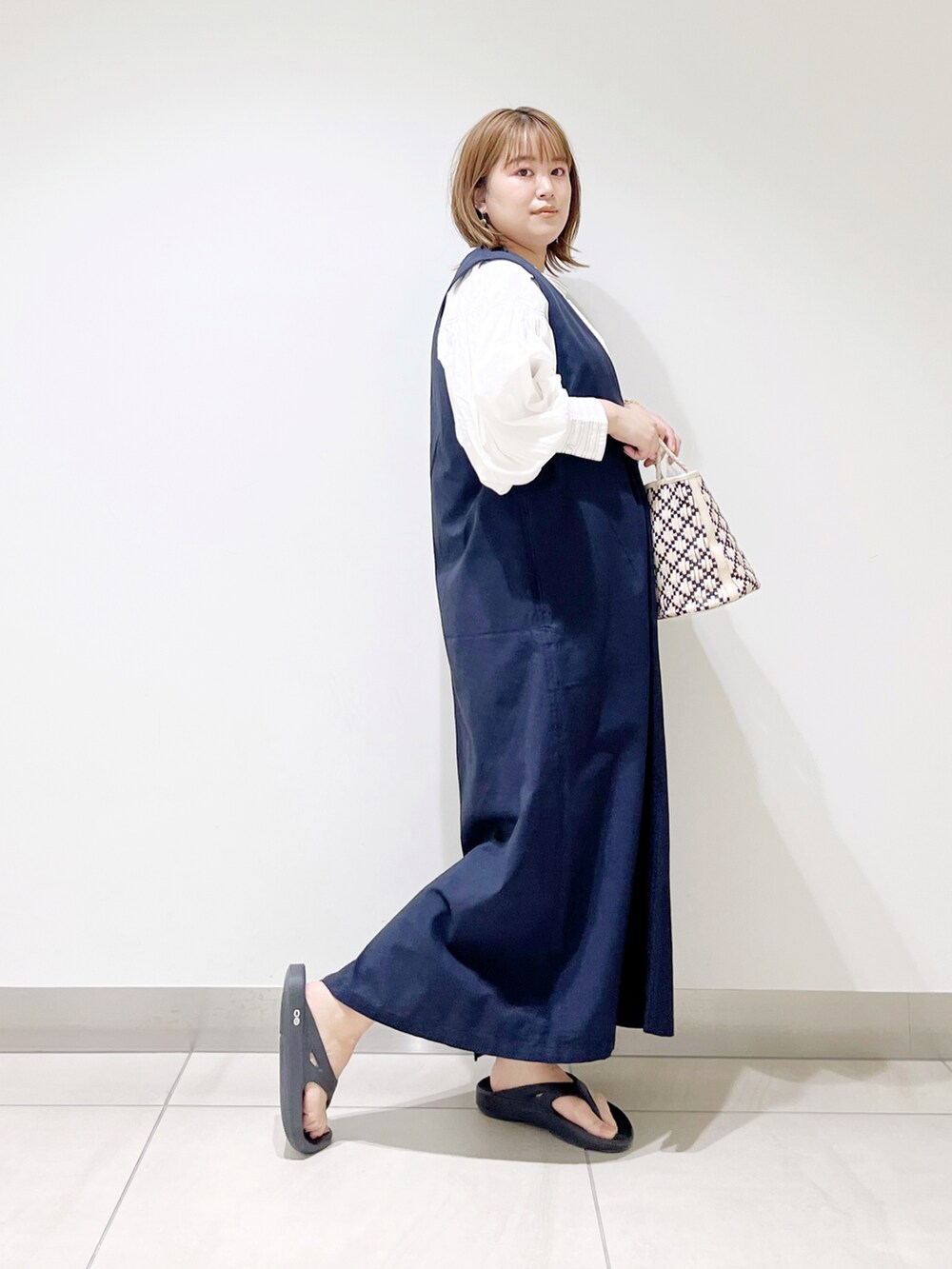 ホワイト系のTシャツ/カットソー、ホワイト系のハンドバッグ、ブルー系のワンピースを着用したレディースの春コーディネートの3枚目の写真