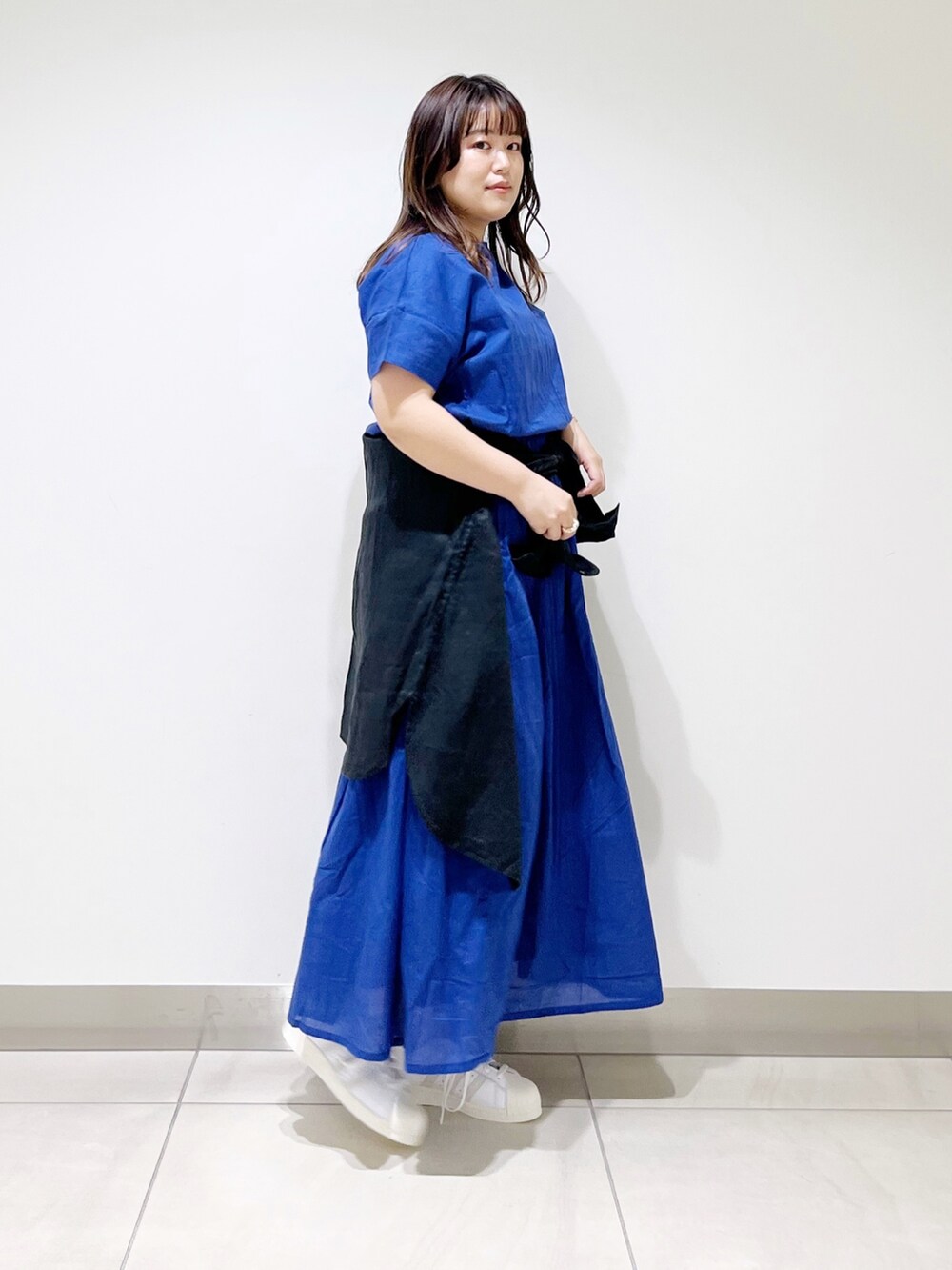 ブルー系のワンピース、ブラック系のシャツ/ブラウス、ホワイト系のスニーカーを着用したレディースの春コーディネートの6枚目の写真