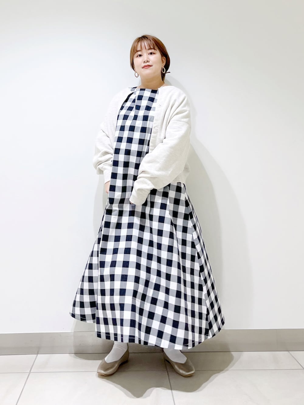 ブラック系のワンピース、グレー系のカーディガン/ボレロ、ゴールド系のパンプスを着用したレディースの春コーディネートの4枚目の写真