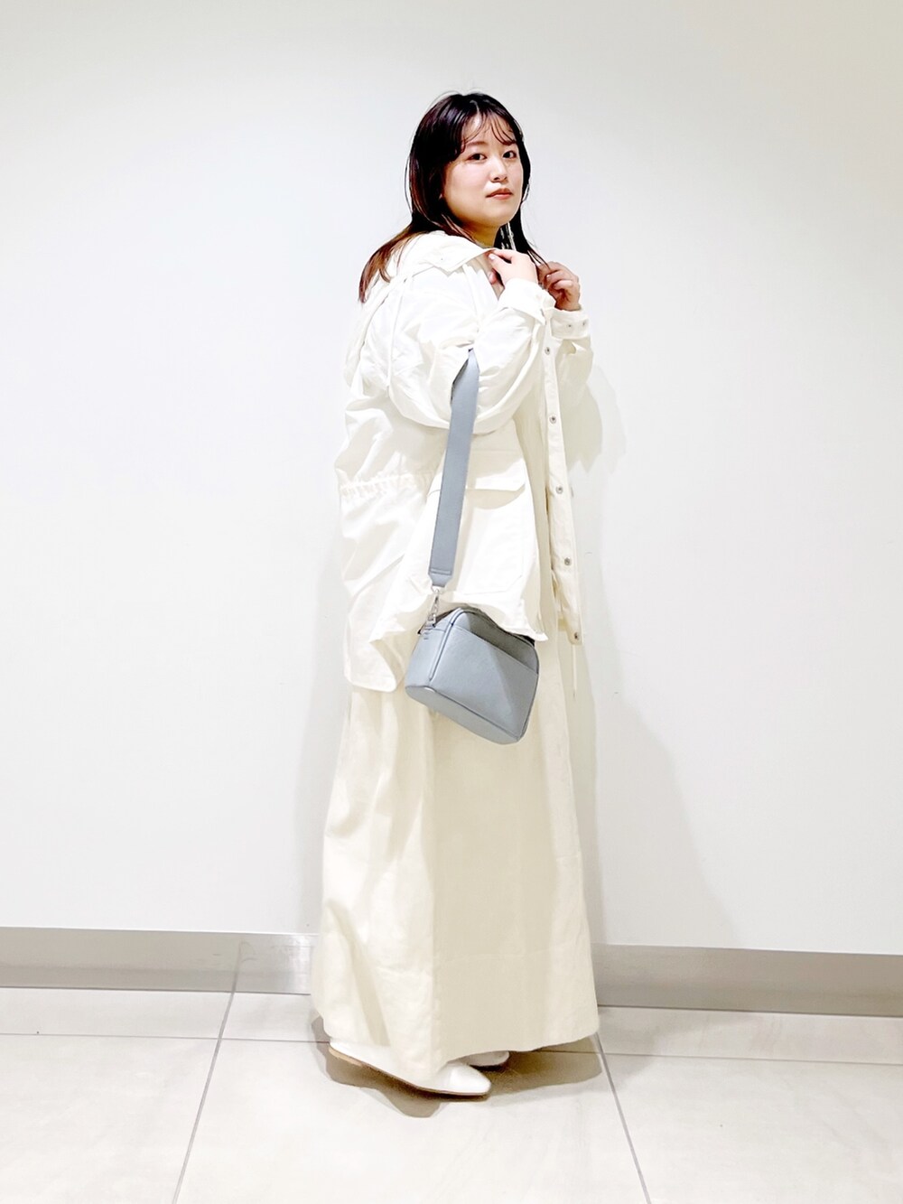 ベージュ系のワンピース、ホワイト系のブルゾン、グリーン系のTシャツ/カットソーを着用したレディースの春コーディネートの5枚目の写真