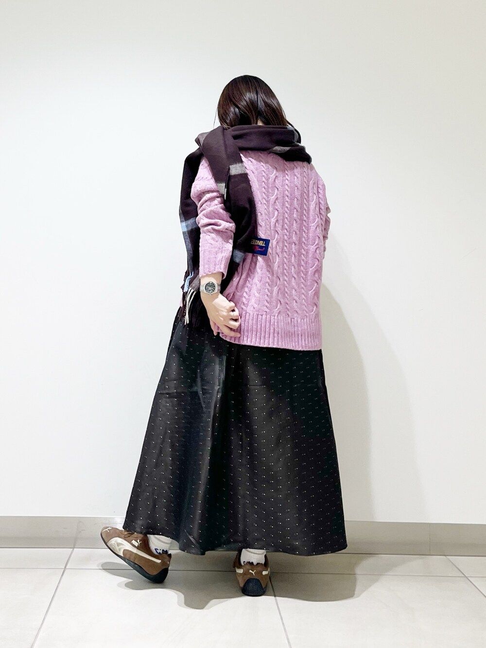 パープル系のニット/セーター、ブルー系のスカート、ブラック系のスニーカーを着用したレディースの秋コーディネートの7枚目の写真