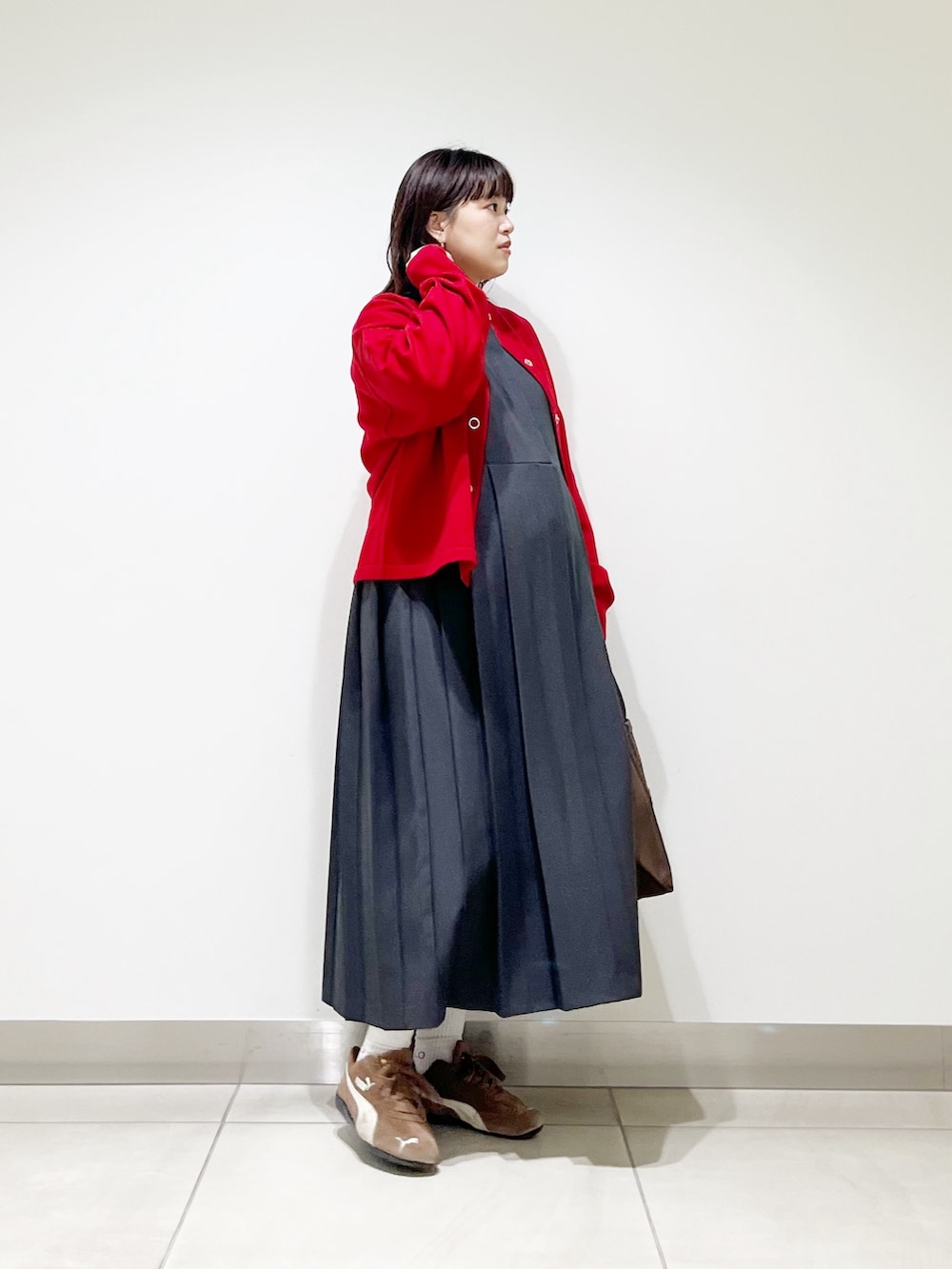 グレー系のワンピース、ブラウン系のトートバッグ、レッド系のカーディガン/ボレロを着用したレディースの秋コーディネートの9枚目の写真