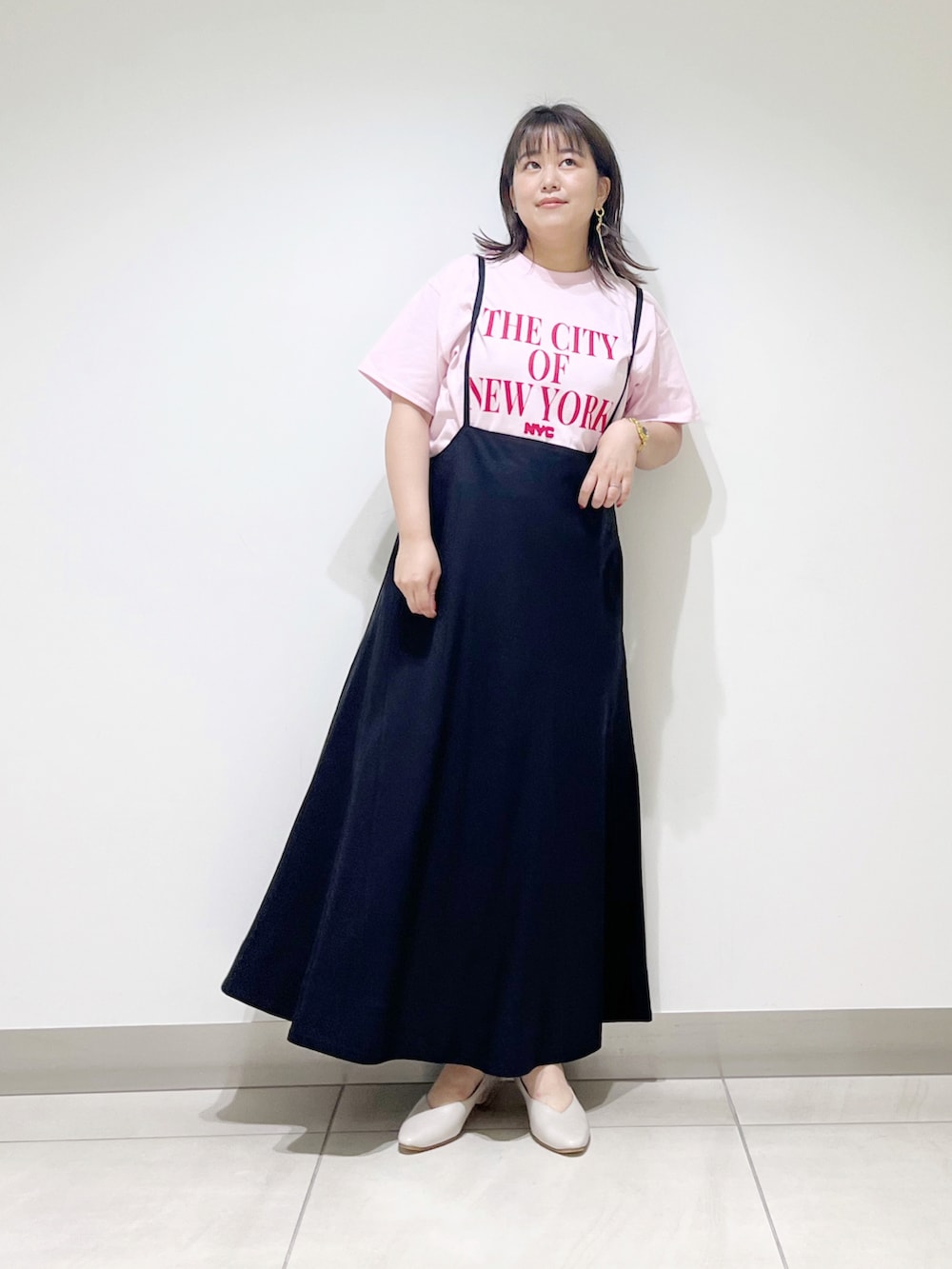 ピンク系のTシャツ/カットソー、ブラック系のスカート、ベージュ系のパンプスを着用したレディースの夏コーディネートの5枚目の写真