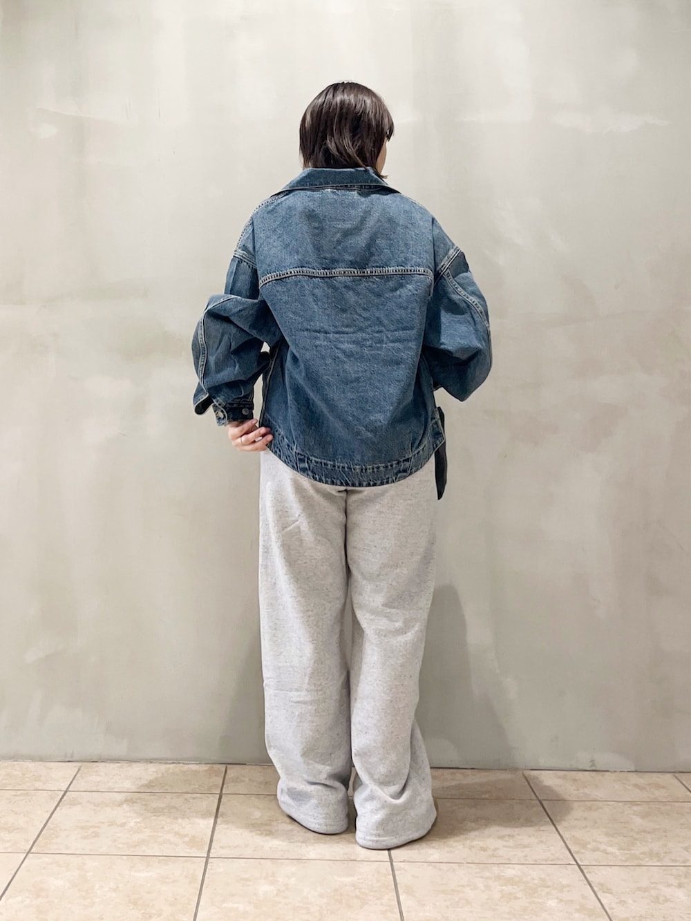 ブルー系のデニムジャケット、ブラック系のスニーカー、グレー系のその他パンツを着用したレディースの秋コーディネートの7枚目の写真