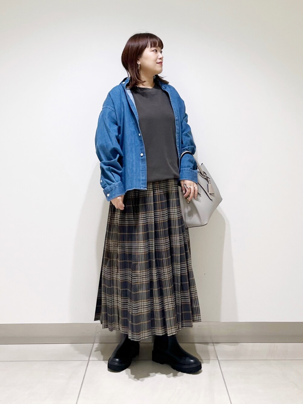 グレー系のTシャツ/カットソー、グレー系のトートバッグ、グレー系のスカートを着用したレディースの秋コーディネートの7枚目の写真