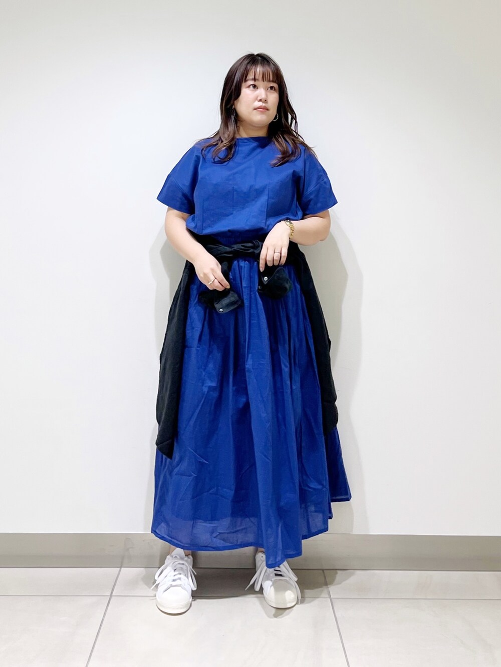 ブルー系のワンピース、ブラック系のシャツ/ブラウス、ホワイト系のスニーカーを着用したレディースの春コーディネートの4枚目の写真