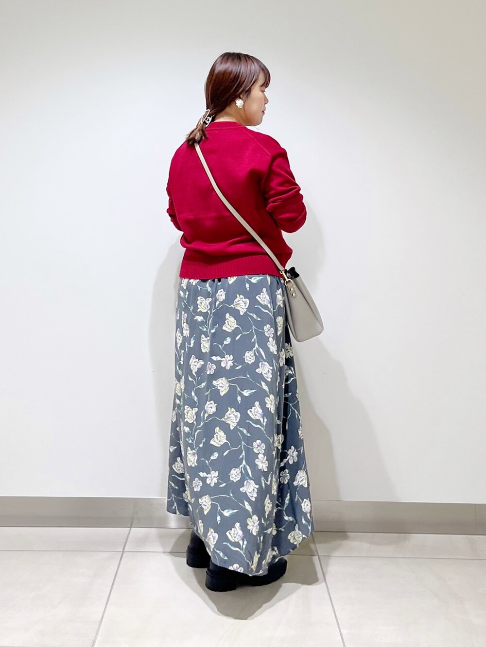 レッド系のトップス、グレー系のスカート、グレー系のショルダーバッグを着用したレディースの秋コーディネートの3枚目の写真