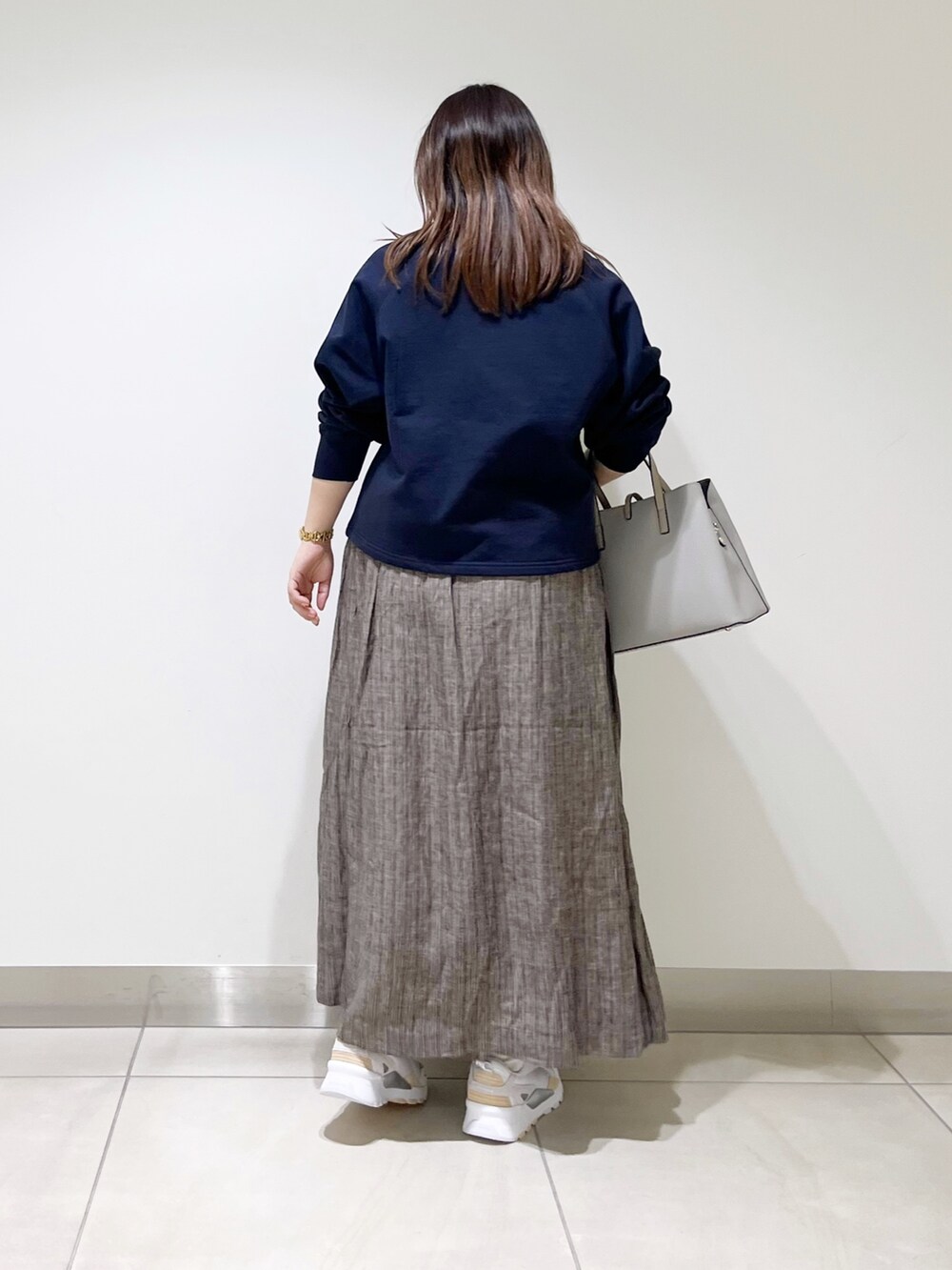 ブルー系のカーディガン/ボレロ、グレー系のトートバッグ、ブラウン系のスカートを着用したレディースの春コーディネートの4枚目の写真