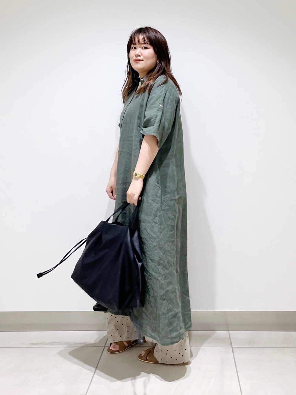 グリーン系のワンピース、ブラック系のトートバッグ、ベージュ系のその他パンツを着用したレディースの夏コーディネートの2枚目の写真