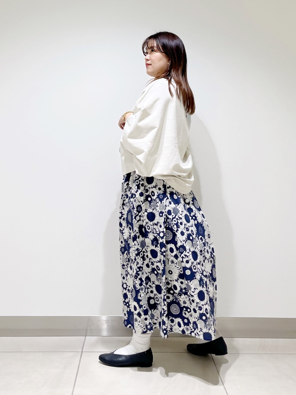 ベージュ系のTシャツ/カットソー、ブルー系のスカート、ブラック系のパンプスを着用したレディースの春コーディネートの4枚目の写真