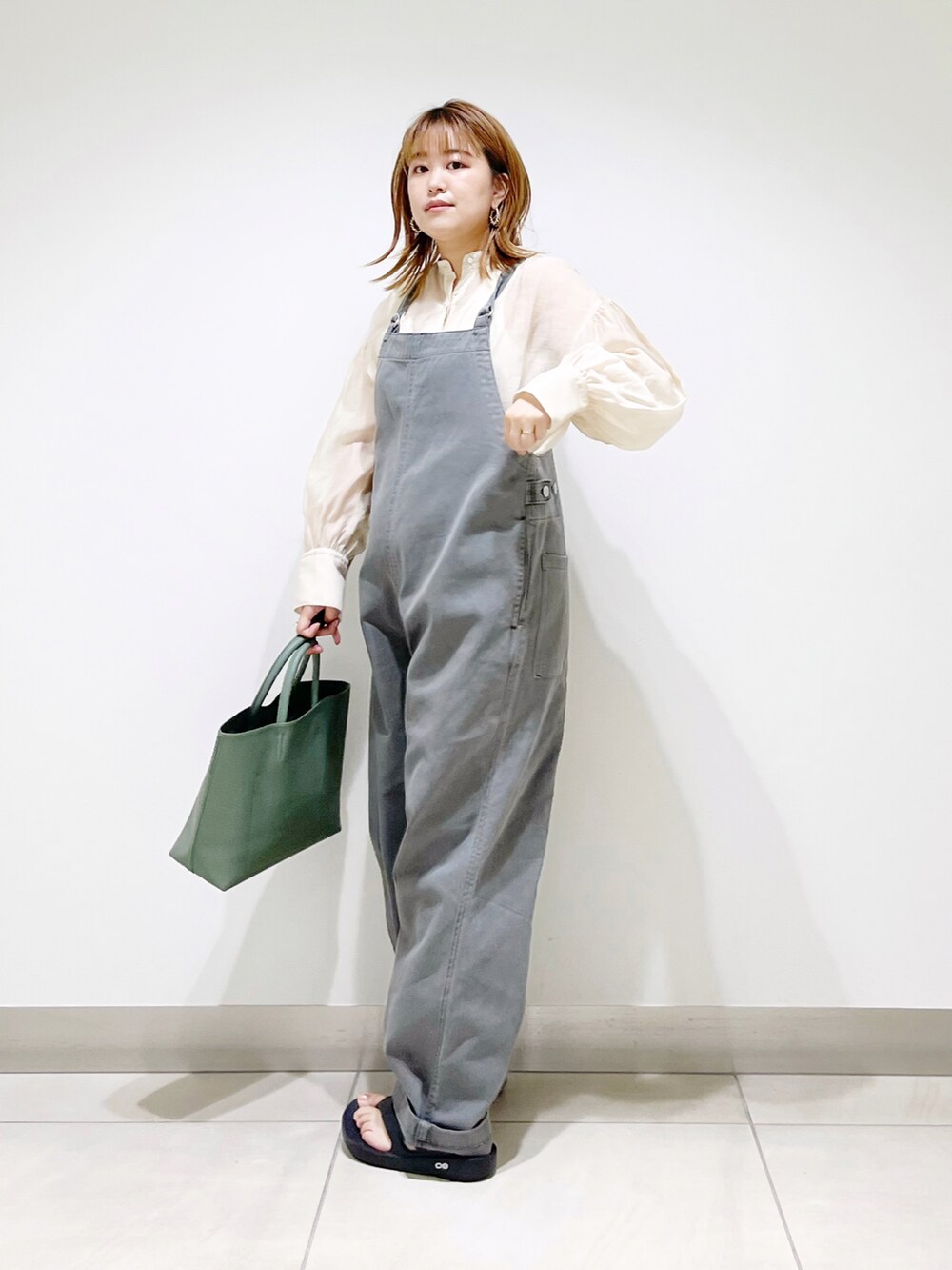 グレー系のサロペット/オーバーオール、グリーン系のトートバッグ、ブラック系のサンダルを着用したレディースの夏コーディネートの3枚目の写真