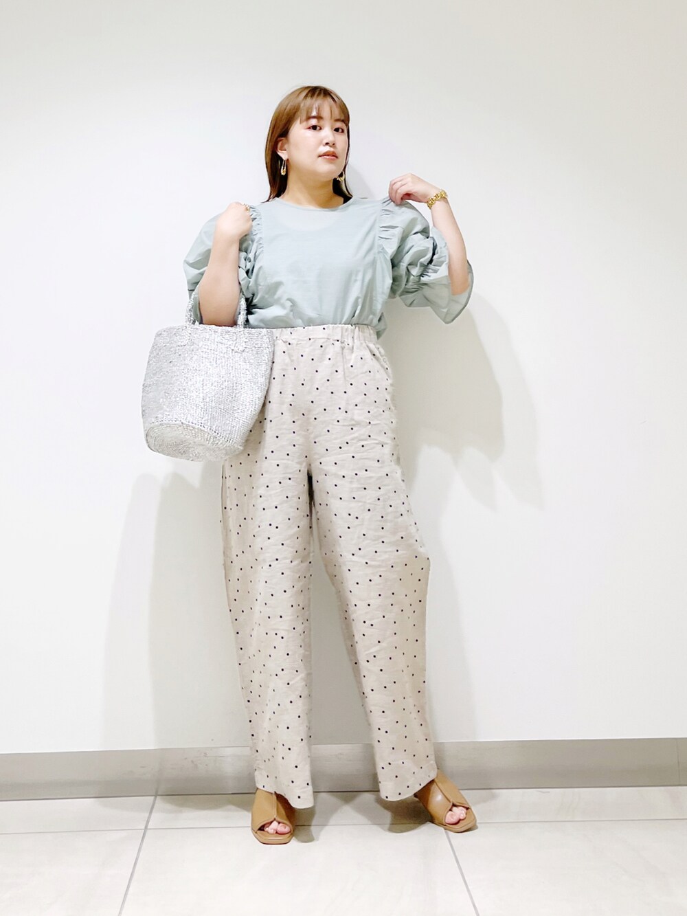 ベージュ系のその他パンツ、グリーン系のシャツ/ブラウス、シルバー系のトートバッグを着用したレディースの夏コーディネートの2枚目の写真