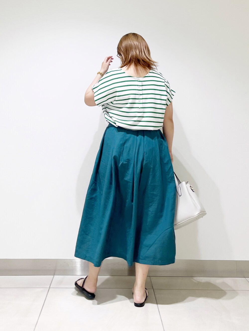 グリーン系のTシャツ/カットソー、グリーン系のスカート、グレー系のトートバッグを着用したレディースの夏コーディネートの5枚目の写真