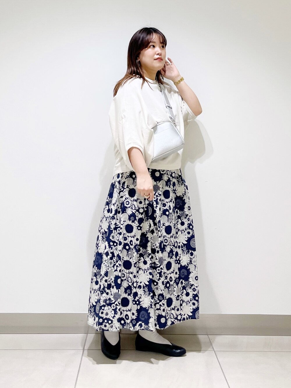 ベージュ系のTシャツ/カットソー、ブルー系のスカート、ブラック系のパンプスを着用したレディースの春コーディネートの5枚目の写真