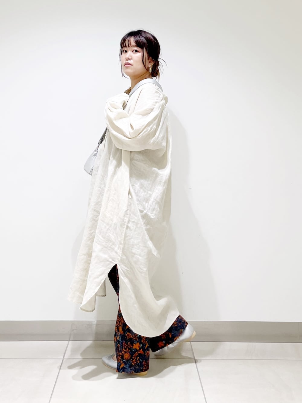 オレンジ系のその他パンツ、シルバー系のバレエシューズ、シルバー系のショルダーバッグを着用したレディースの夏コーディネートの6枚目の写真