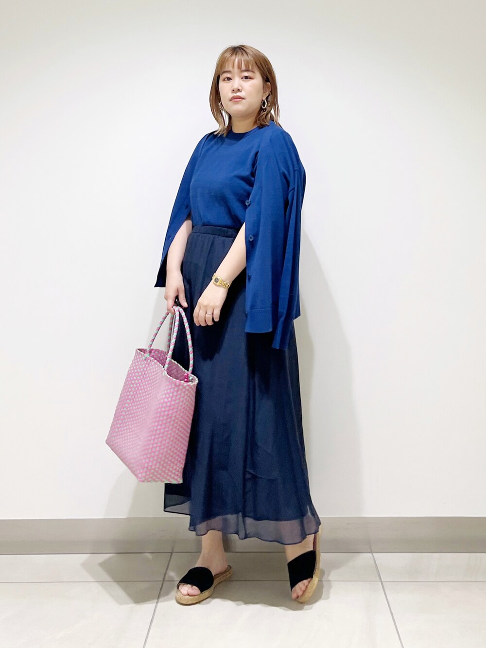 ブルー系のニット/セーター、ブルー系のカーディガン/ボレロ、ブルー系のスカートを着用したレディースの春コーディネートの5枚目の写真