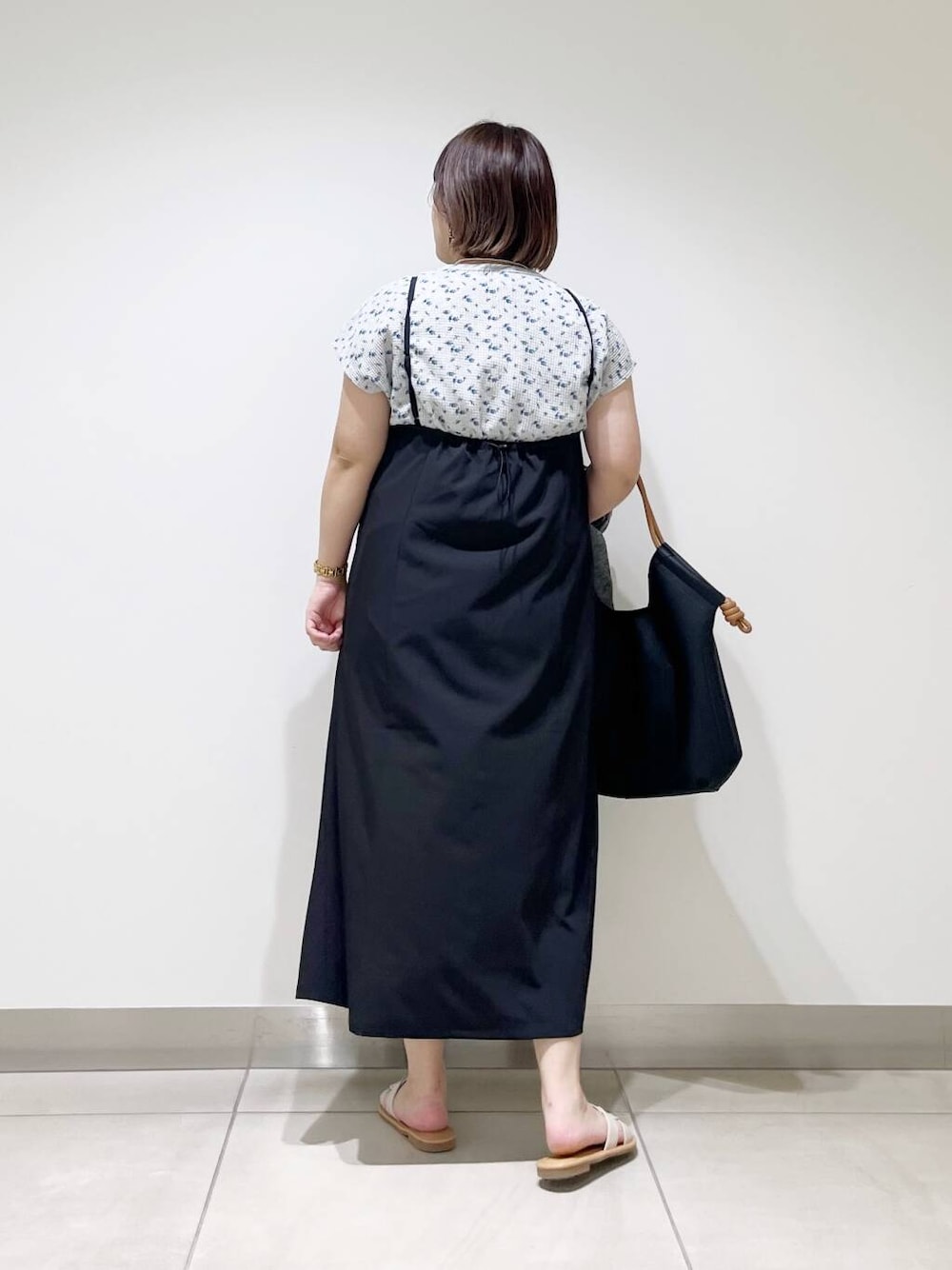 ブラック系のトートバッグ、グレー系のカーディガン/ボレロ、ホワイト系のサンダルを着用したレディースの春コーディネートの6枚目の写真