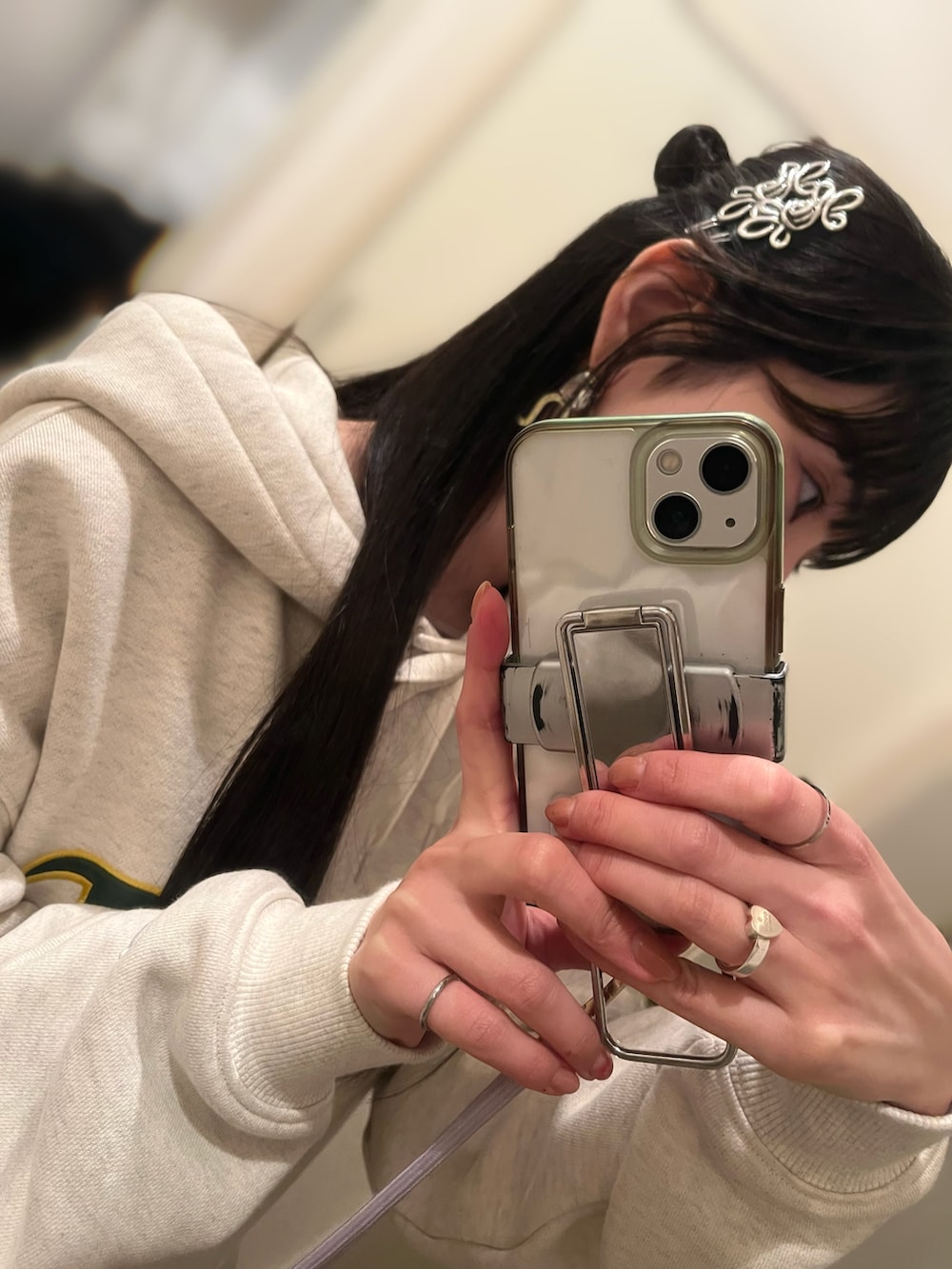 ベージュ系のパーカー、グレー系のスカート、ホワイト系のスニーカーを着用したレディースの春コーディネートの2枚目の写真