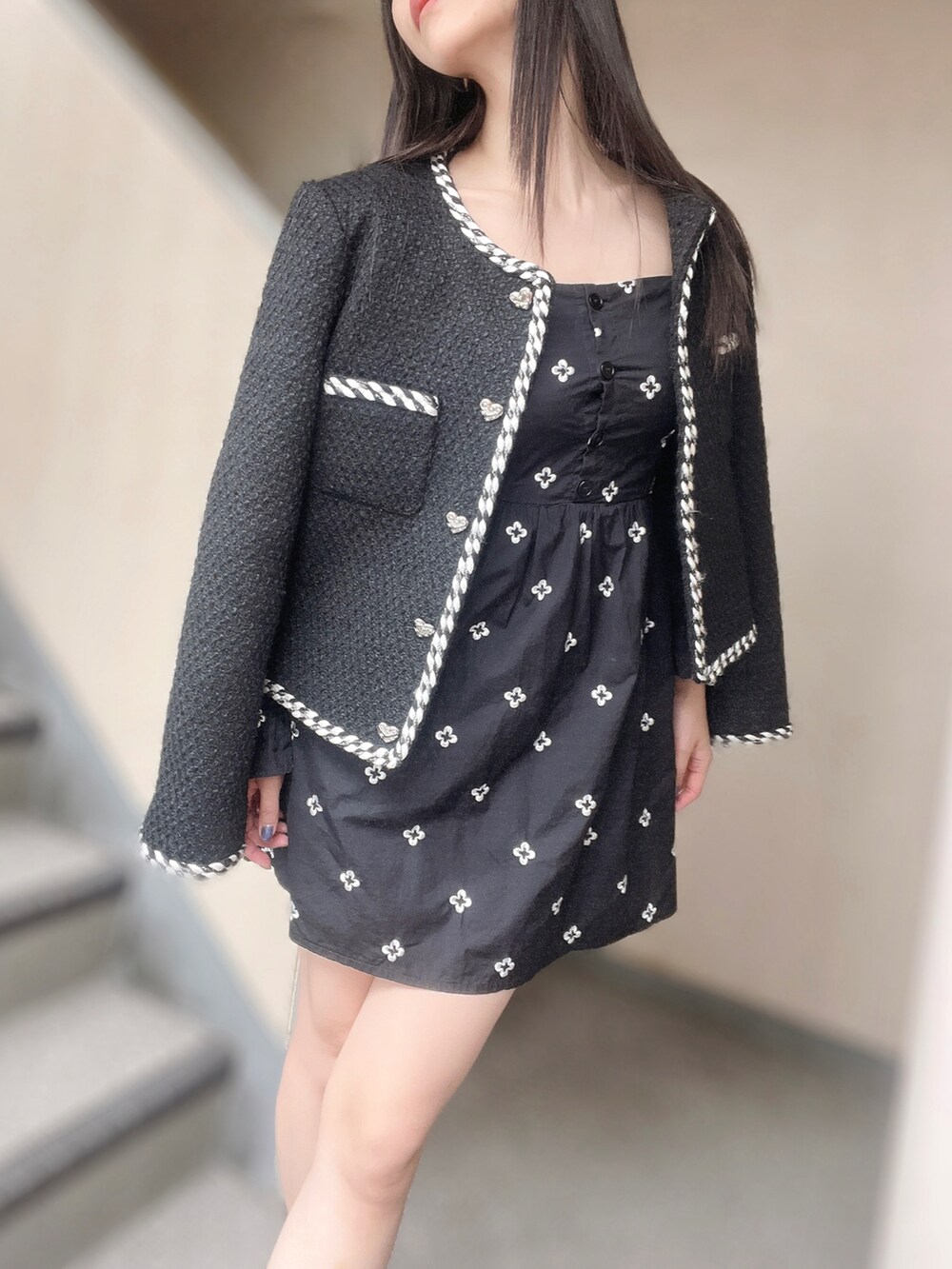 ブラック系のノーカラージャケット、ブラック系のワンピース、ブラック系のブーツを着用したレディースの秋コーディネートの3枚目の写真