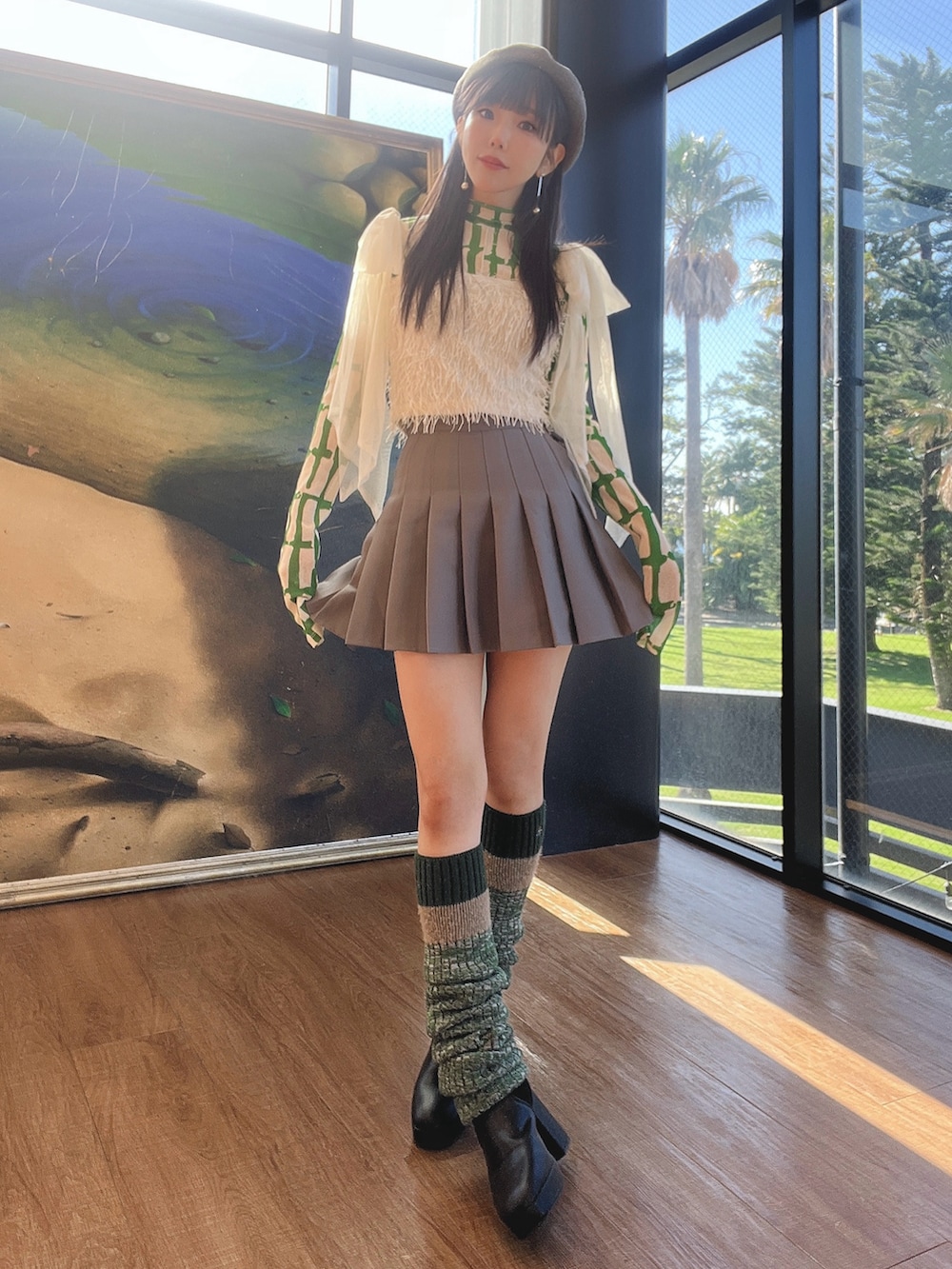 グレー系のスカート、ホワイト系のその他トップス、グリーン系のTシャツ/カットソーを着用したレディースの冬コーディネートの3枚目の写真