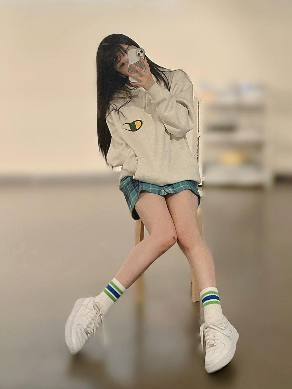 ホワイト系のスニーカー、グリーン系のスカート、ベージュ系のパーカーを着用したレディースの春コーディネートの2枚目の写真