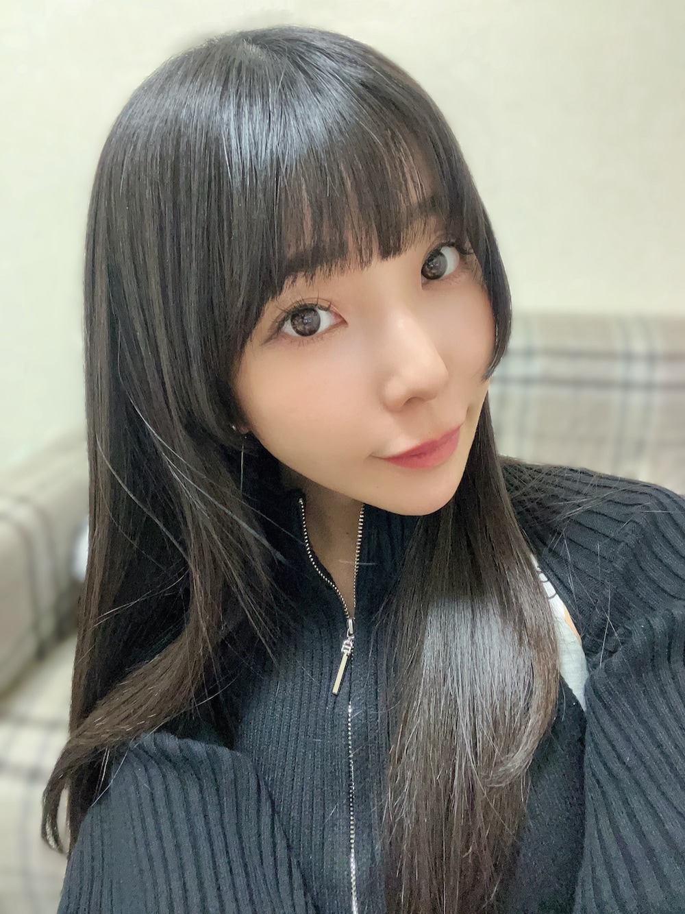 ブラック系のアンサンブル、グレー系のスカート、ブラック系のブーツを着用したレディースの冬コーディネートの2枚目の写真