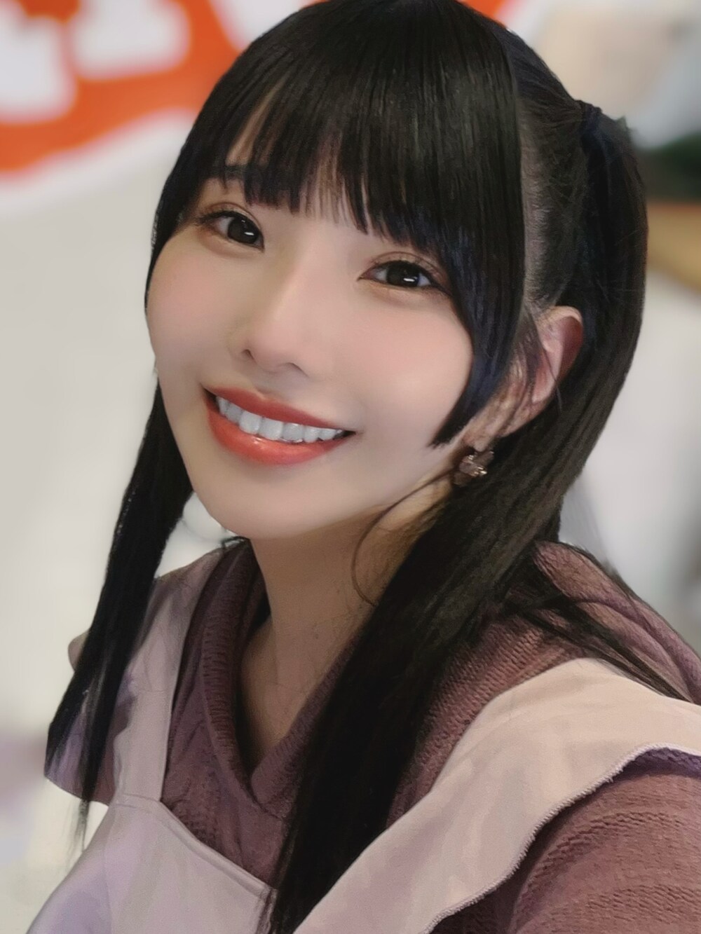 ブラック系のブーツ、ピンク系のニット/セーター、ピンク系のスカートを着用したレディースの冬コーディネートの2枚目の写真