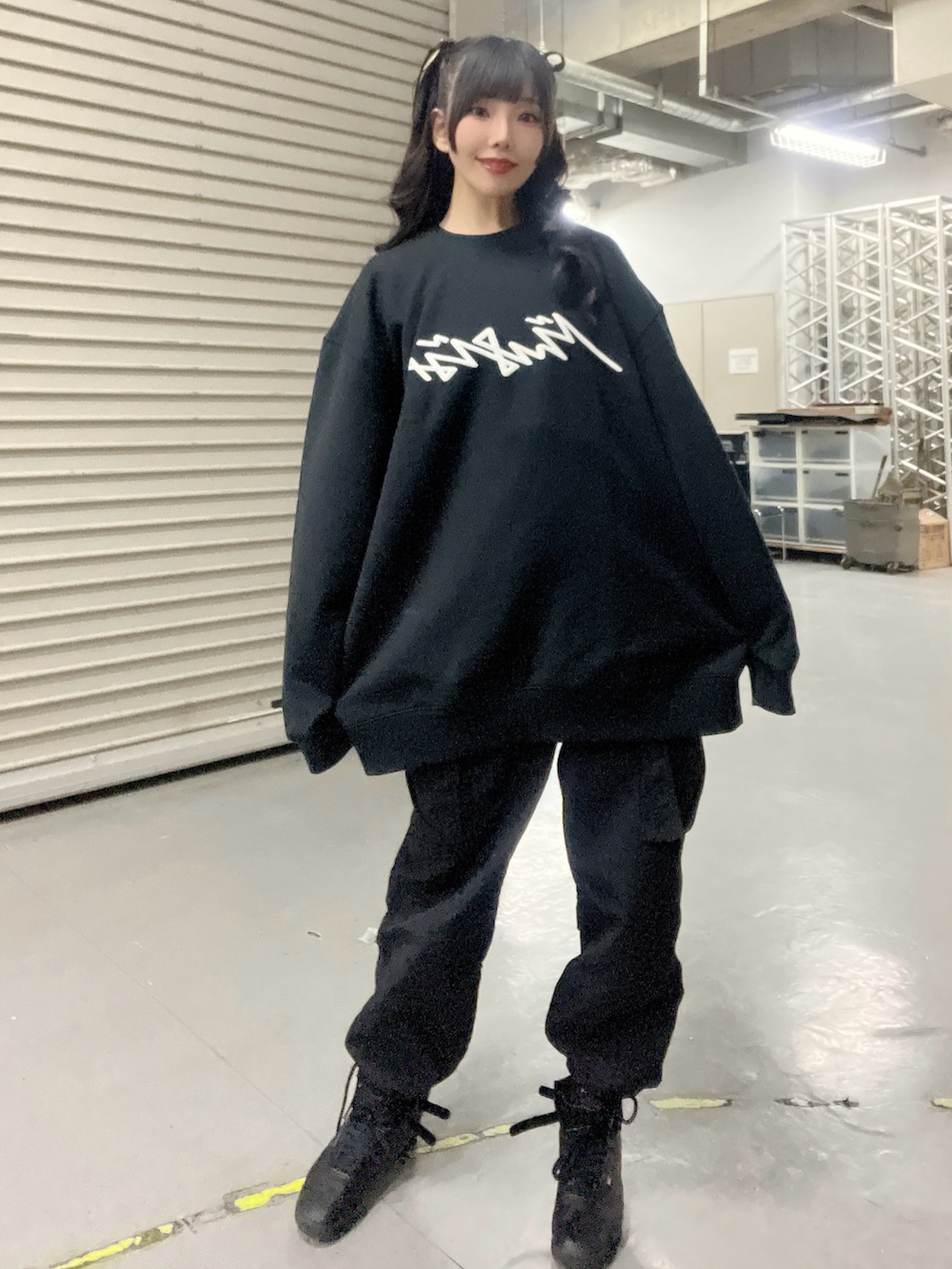 ブラック系のスウェット、ブラック系のカーゴパンツ、ブラック系のスニーカーを着用したレディースの冬コーディネートの2枚目の写真