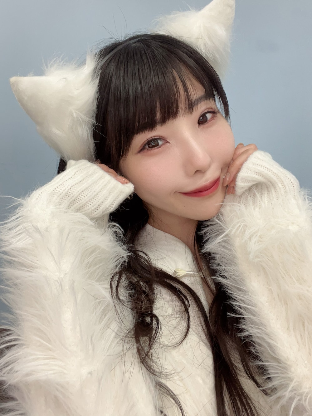 ホワイト系のカーディガン/ボレロ、ホワイト系のブーツ、ピンク系のアイシャドウを着用したレディースの冬コーディネートの2枚目の写真