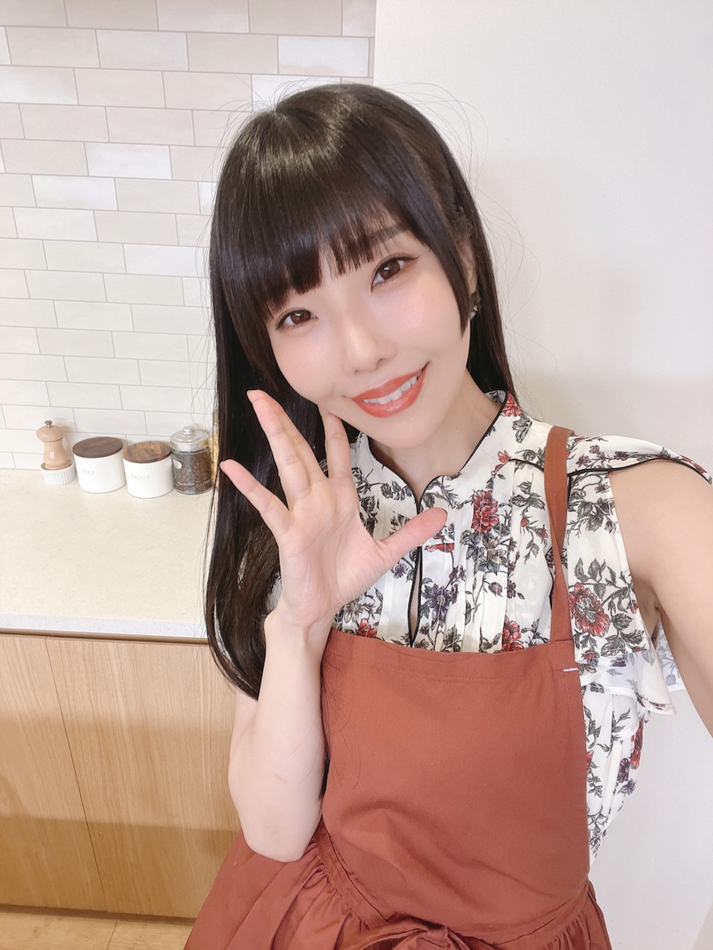 ホワイト系のワンピース、オレンジ系のパンプス、ブラウン系のエプロンを着用したレディースの秋コーディネートの2枚目の写真