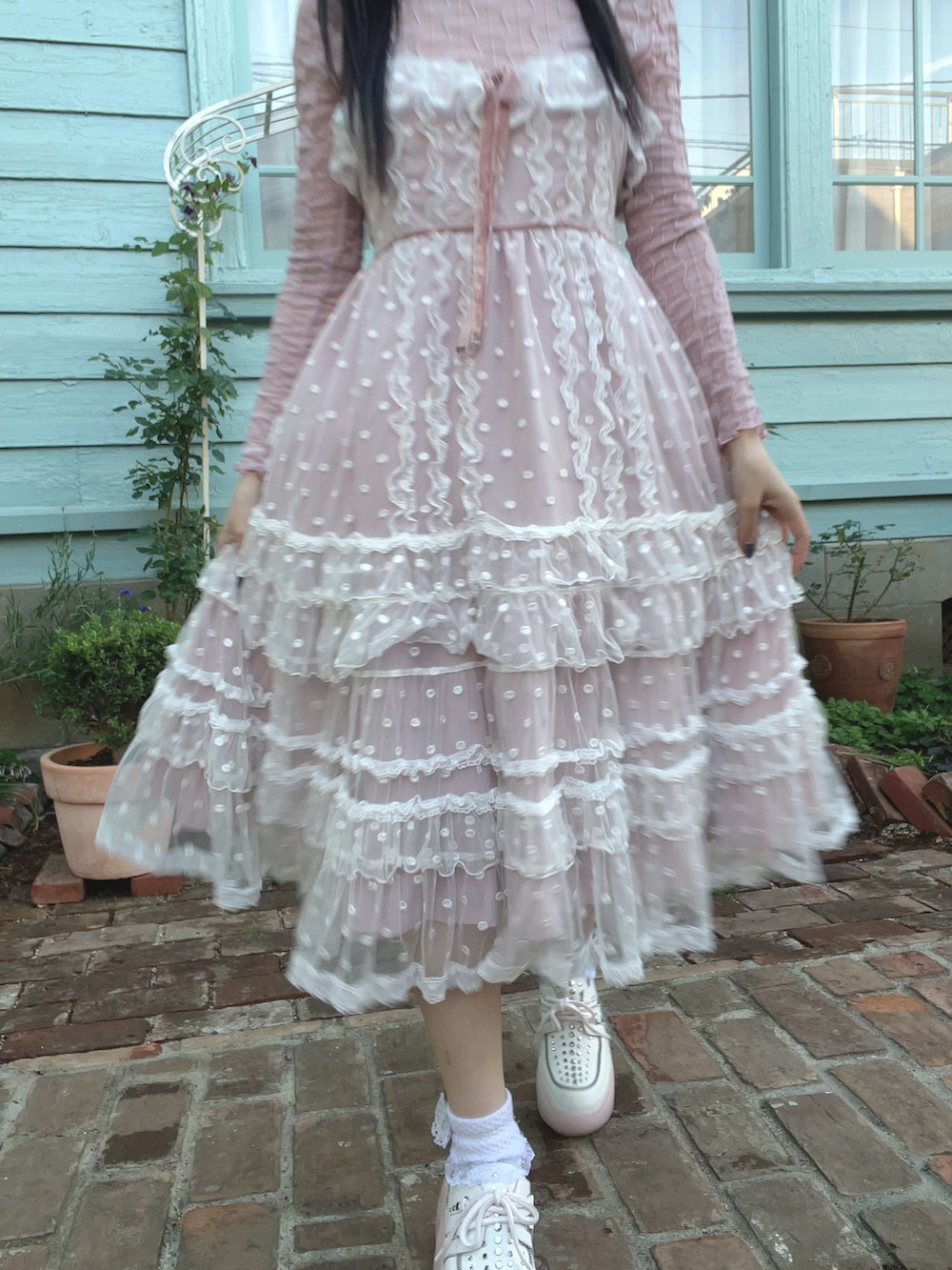 レッド系のハンドバッグ、ピンク系のジャンパースカート、ピンク系のモカシン/デッキシューズを着用したレディースの春コーディネートの3枚目の写真