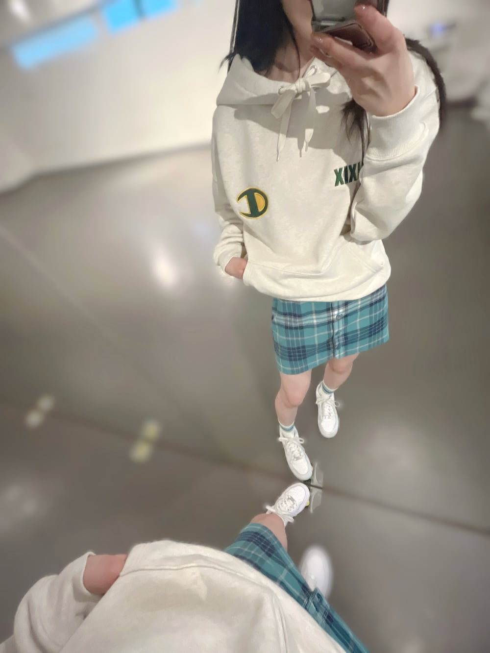 ホワイト系のスニーカー、グリーン系のスカート、ベージュ系のパーカーを着用したレディースの春コーディネートの3枚目の写真