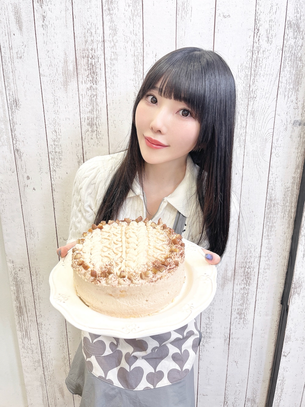 グレー系のスカート、ホワイト系のニット/セーター、ホワイト系のブーツを着用したレディースの秋コーディネートの2枚目の写真