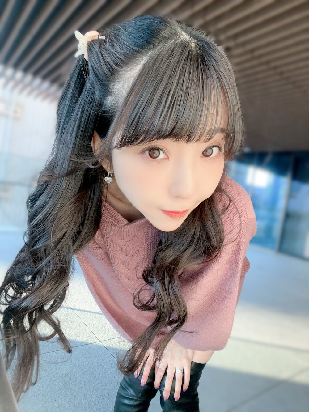 ピンク系のスカート、ピンク系のニット/セーター、ブラック系のブーツを着用したレディースの冬コーディネートの2枚目の写真