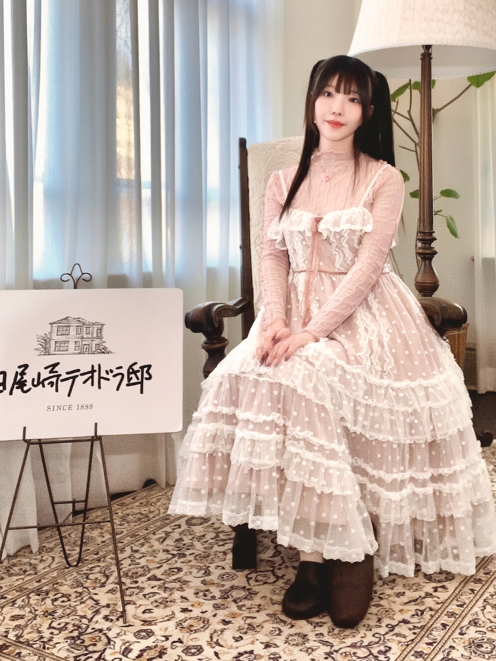 レッド系のハンドバッグ、ピンク系のジャンパースカート、ピンク系のモカシン/デッキシューズを着用したレディースの春コーディネートの2枚目の写真