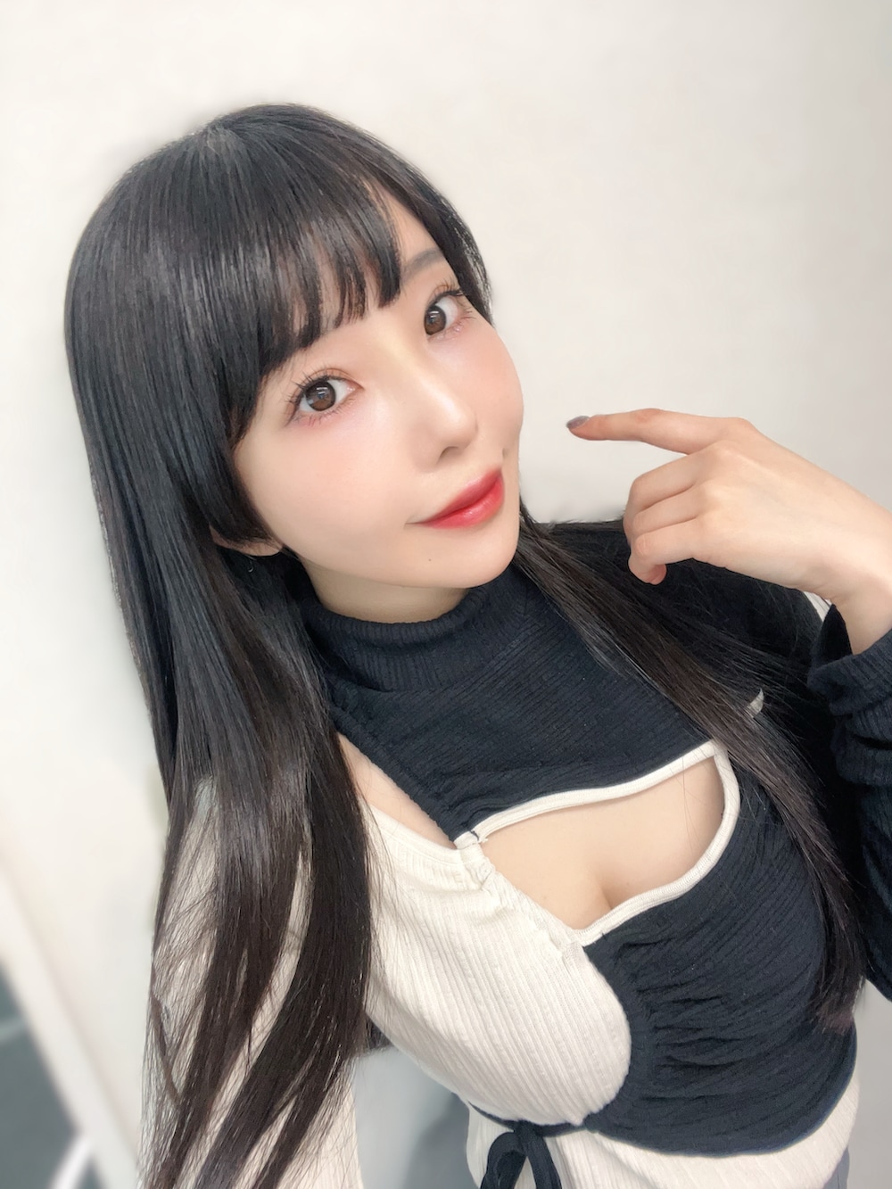 グレー系のスカート、ホワイト系のブーツ、ブラック系のその他トップスを着用したレディースの冬コーディネートの2枚目の写真