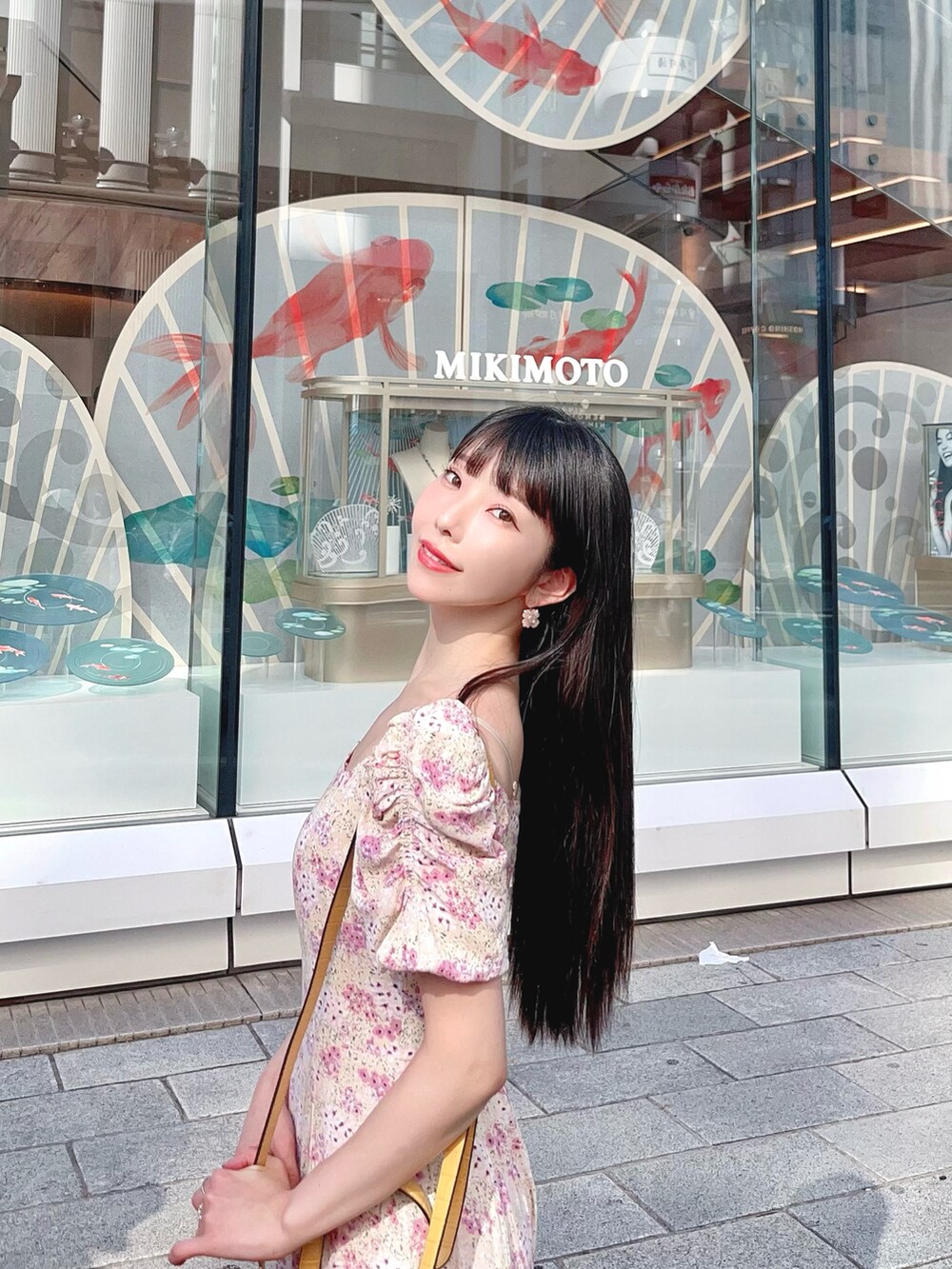 ピンク系のワンピース、イエロー系のトートバッグ、レッド系のサンダルを着用したレディースの夏コーディネートの2枚目の写真