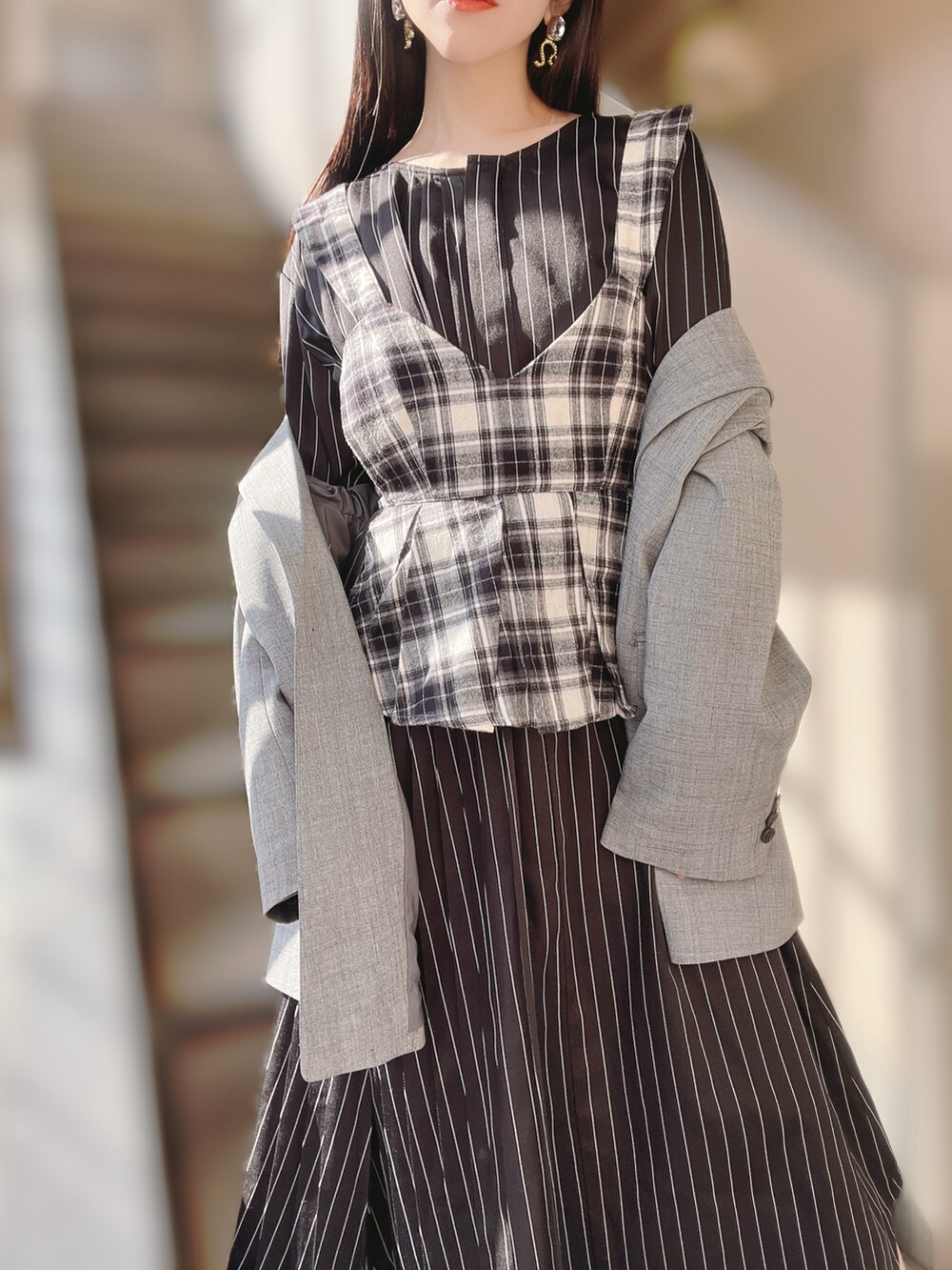 グレー系のテーラードジャケット、ブラック系のその他トップス、ブラック系のワンピースを着用したレディースの春コーディネートの2枚目の写真